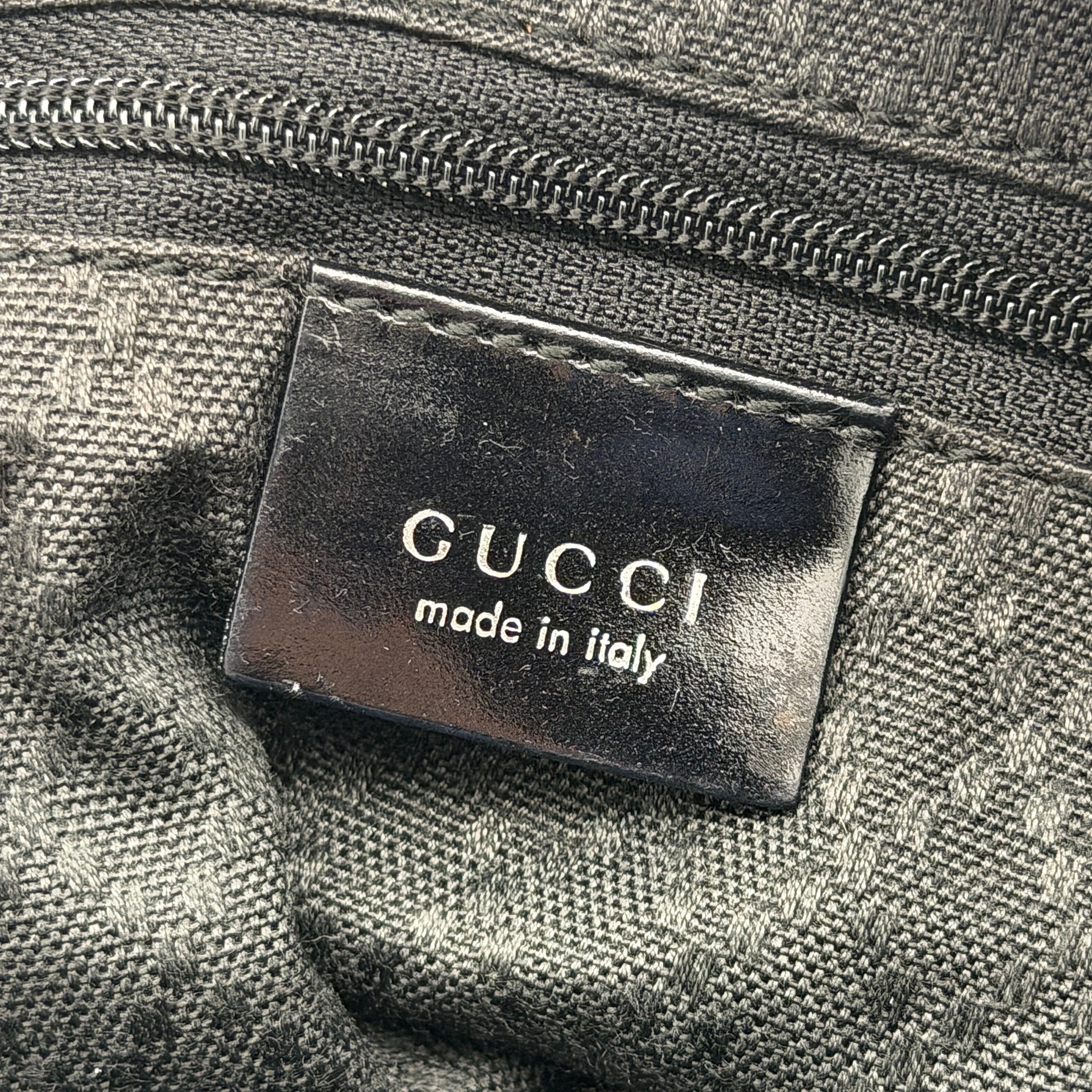 Gucci black nylon shoulder bag with bamboo handle and leather trim, photographed against a white background.