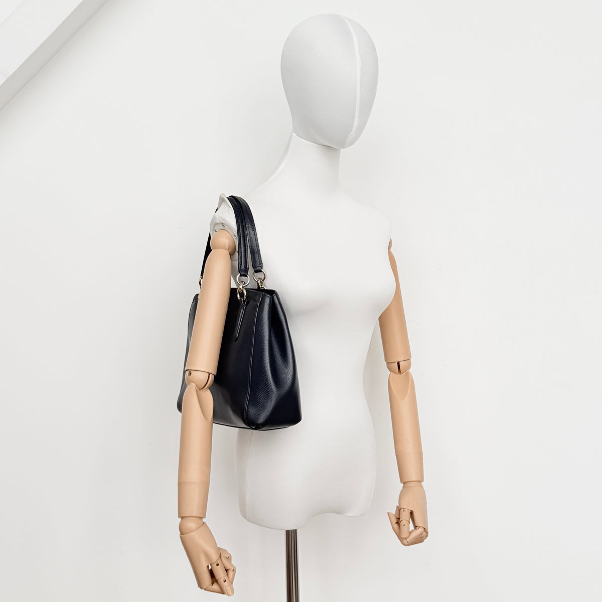 Coach Minetta Satchel in navy blue grained leather with dual handles and detachable shoulder strap displayed on a white background.
