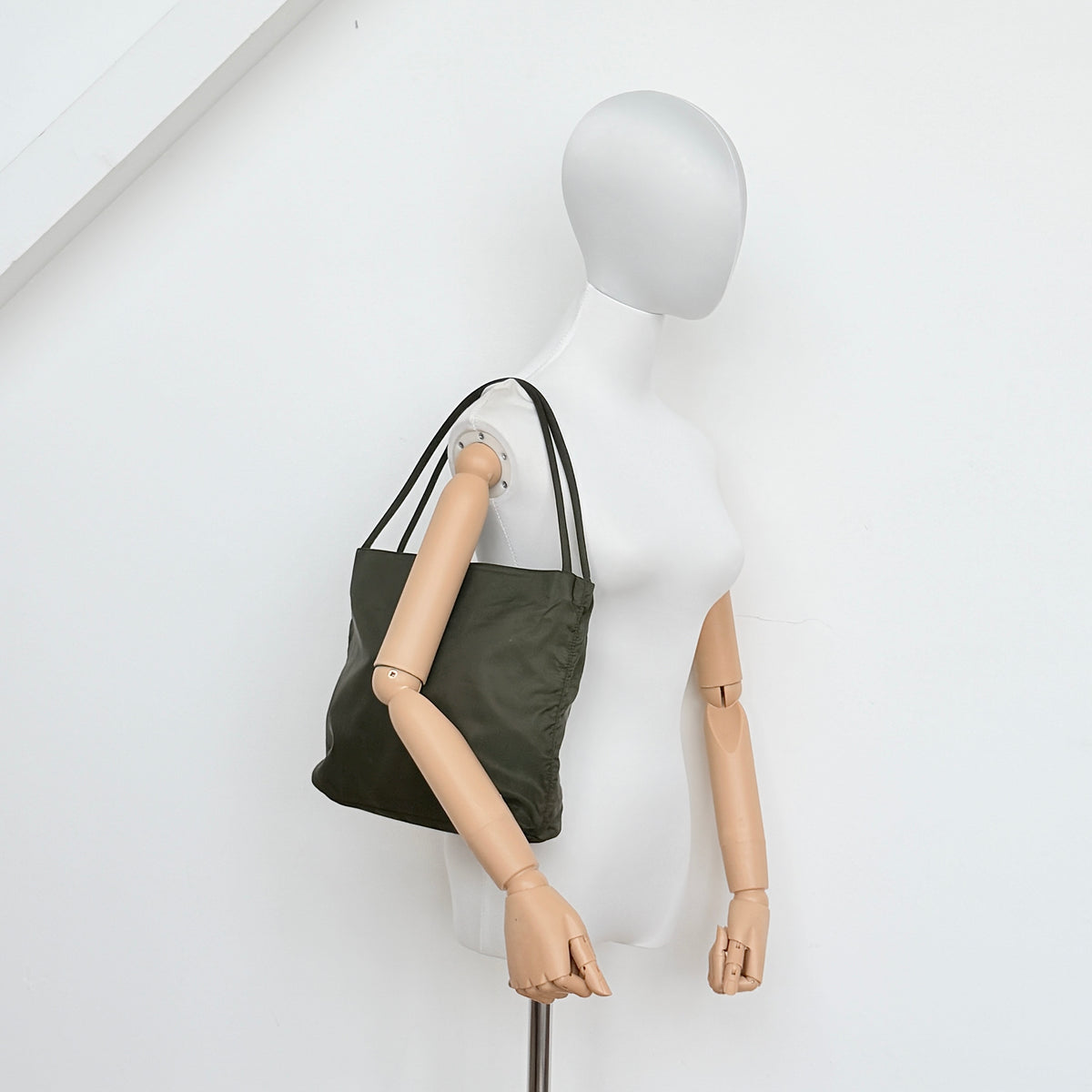 Prada Tessuto Nylon City Tote Bag in dark green nylon with double handles and signature triangle logo plaque on the front.
