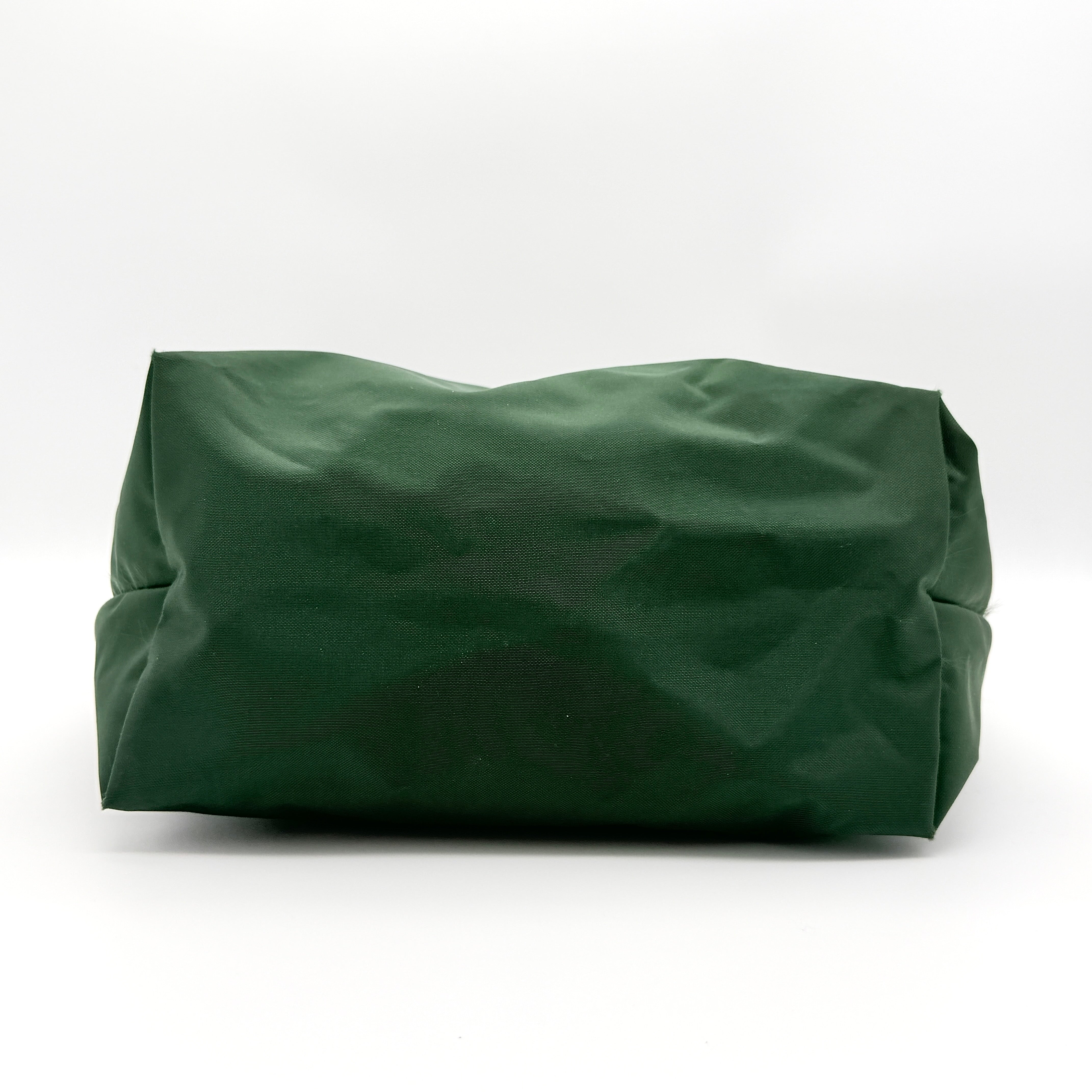 Longchamp Le Pliage Original Tote in green nylon with brown leather handles and gold hardware displayed against a white background.