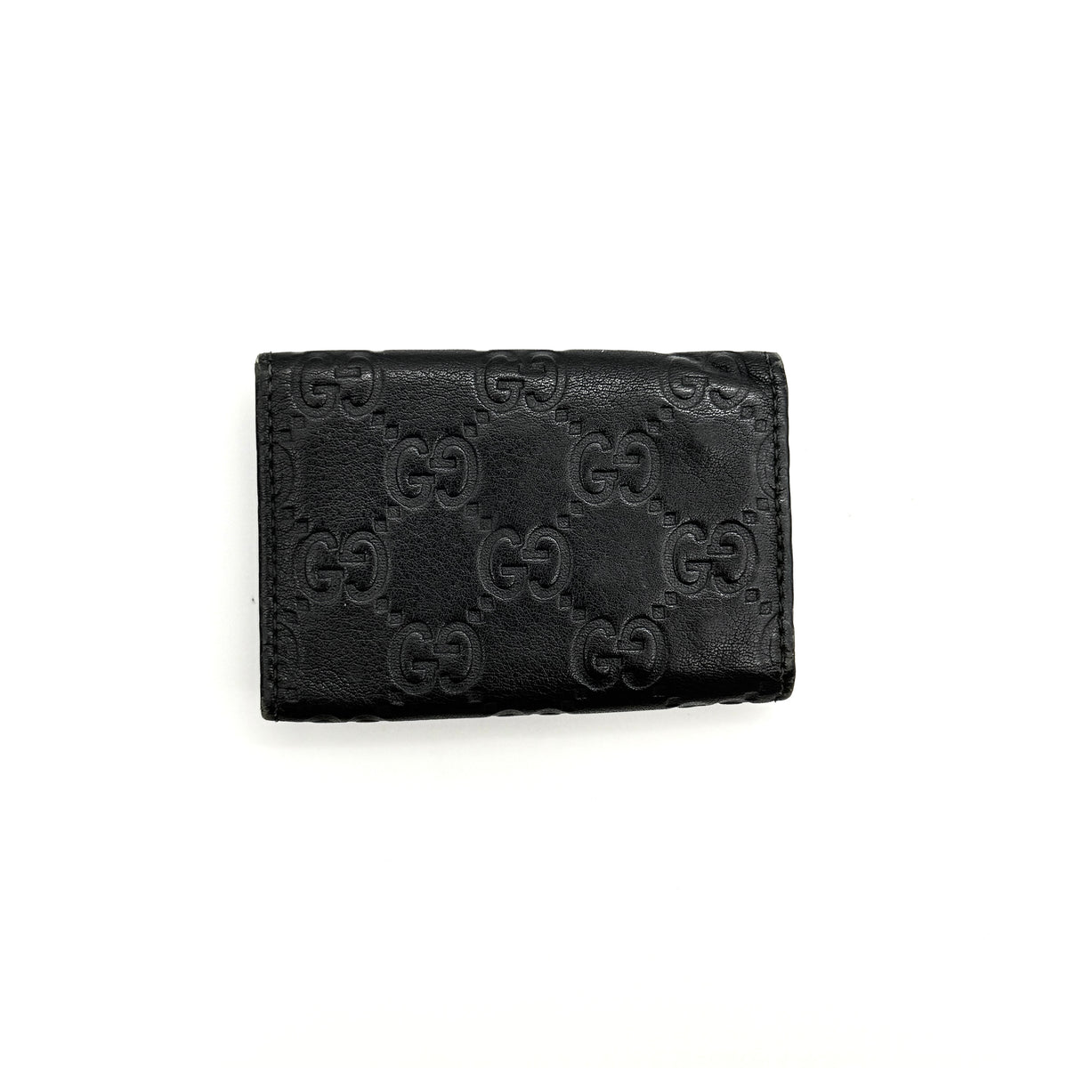 Gucci Guccissima GG Monogram black leather key case with silver-tone hardware, shown closed against a white background.