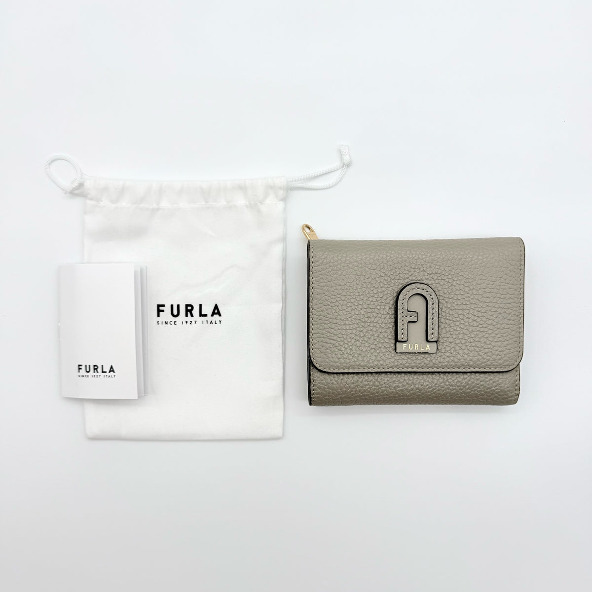 Furla Dafne Trifold Wallet in grey pebbled leather with gold-tone hardware and trifold interior, shown with original dust bag.