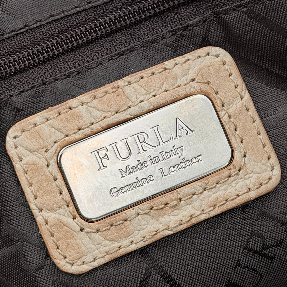 Furla beige croc-embossed leather handbag with double handles and silver-tone logo medallion, photographed on a white background.
