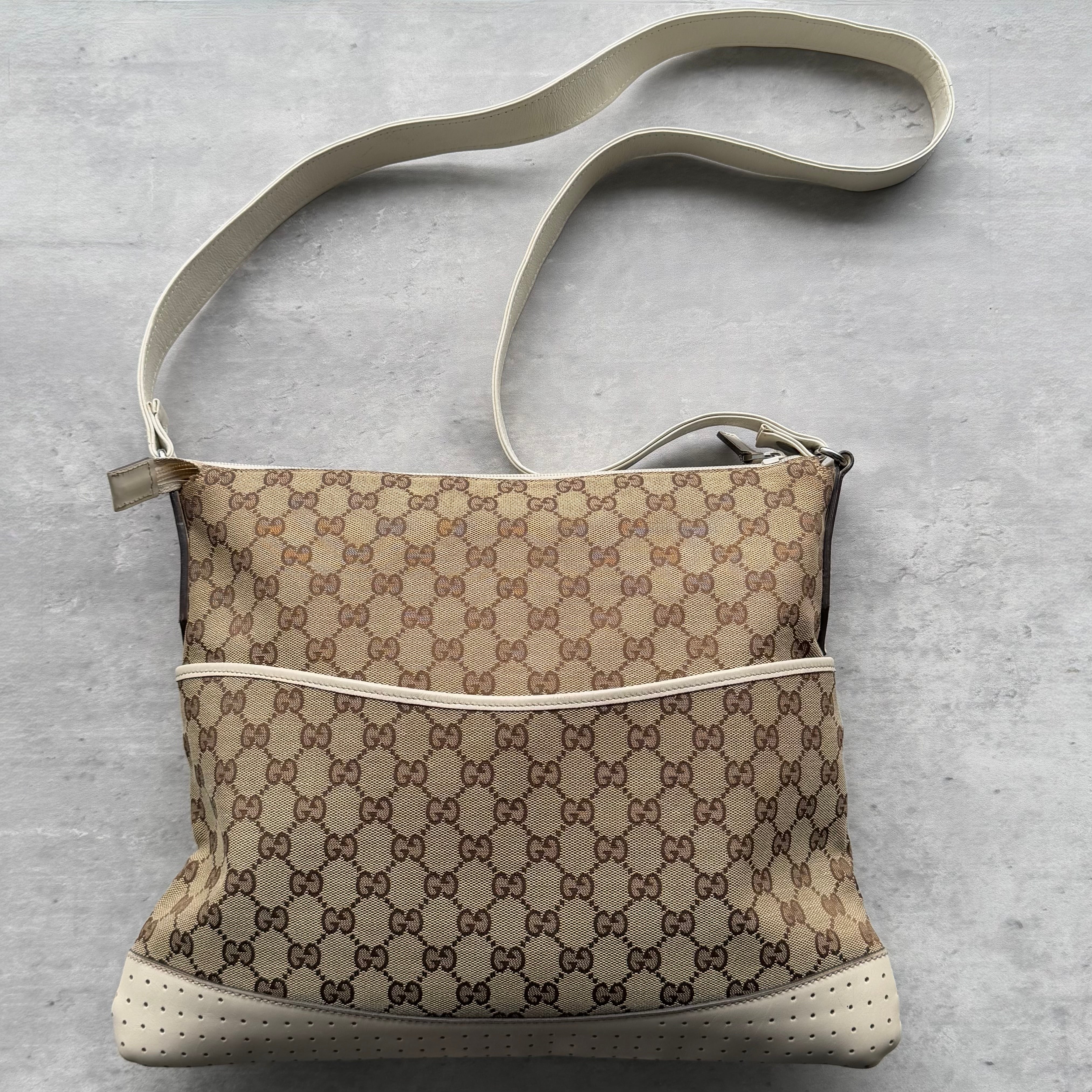 Gucci GG Monogram Crossbody Bag in beige canvas with cream perforated leather trim, adjustable strap, and slim silhouette.