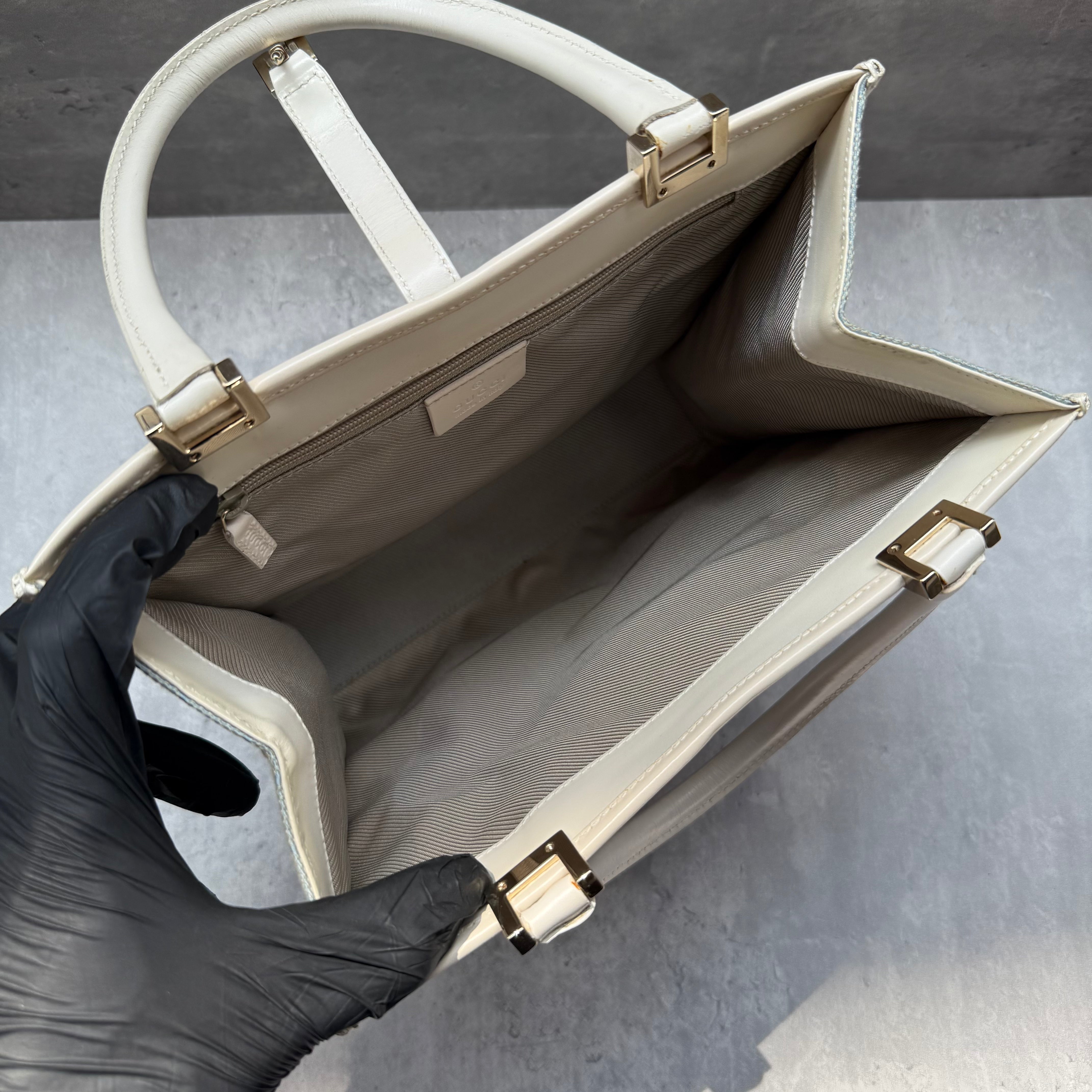 Gucci GG Monogram Jackie Shoulder Bag in light blue canvas with white leather trim, structured silhouette, and silver-tone piston lock.