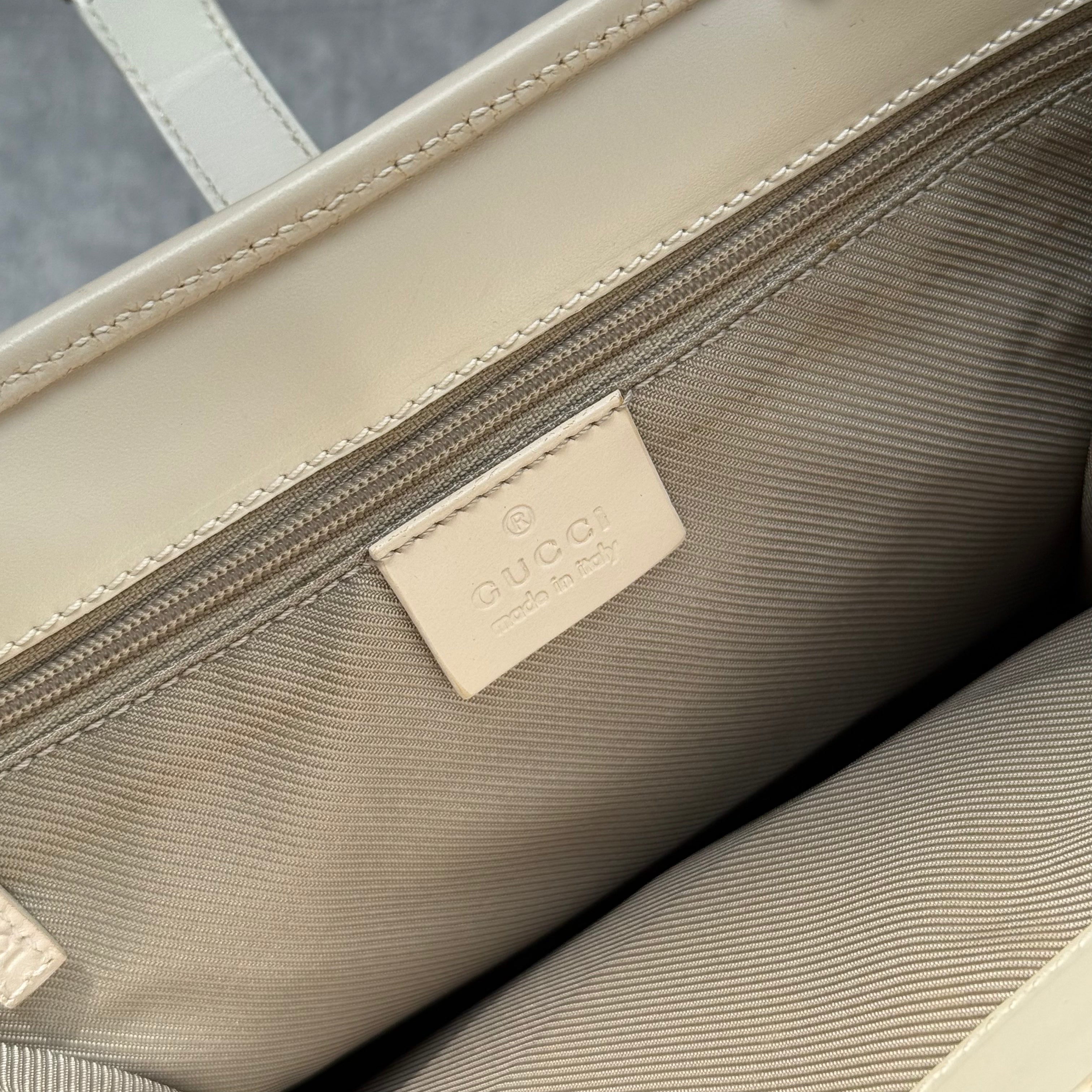 Gucci GG Monogram Jackie Shoulder Bag in light blue canvas with white leather trim, structured silhouette, and silver-tone piston lock.