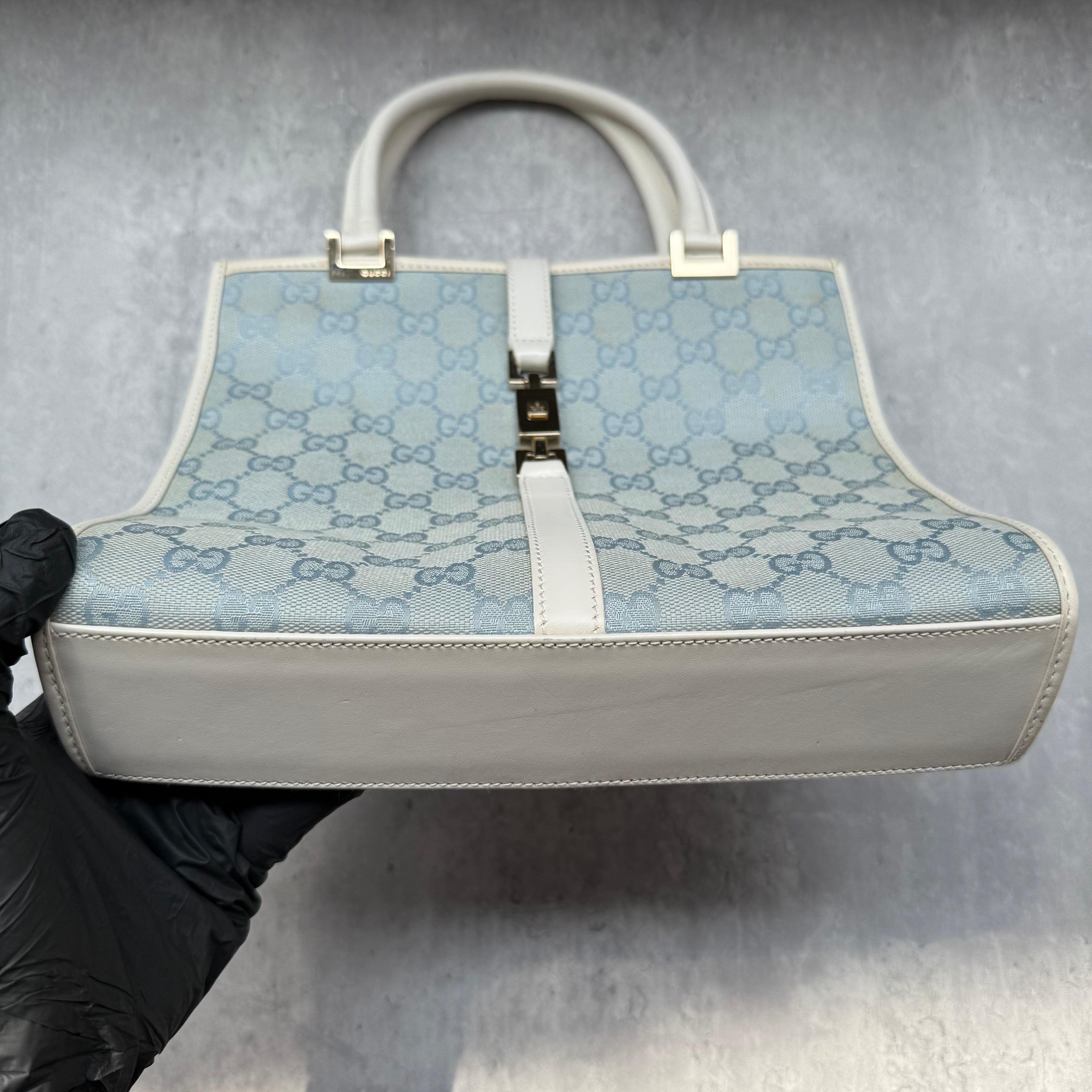 Gucci GG Monogram Jackie Shoulder Bag in light blue canvas with white leather trim, structured silhouette, and silver-tone piston lock.