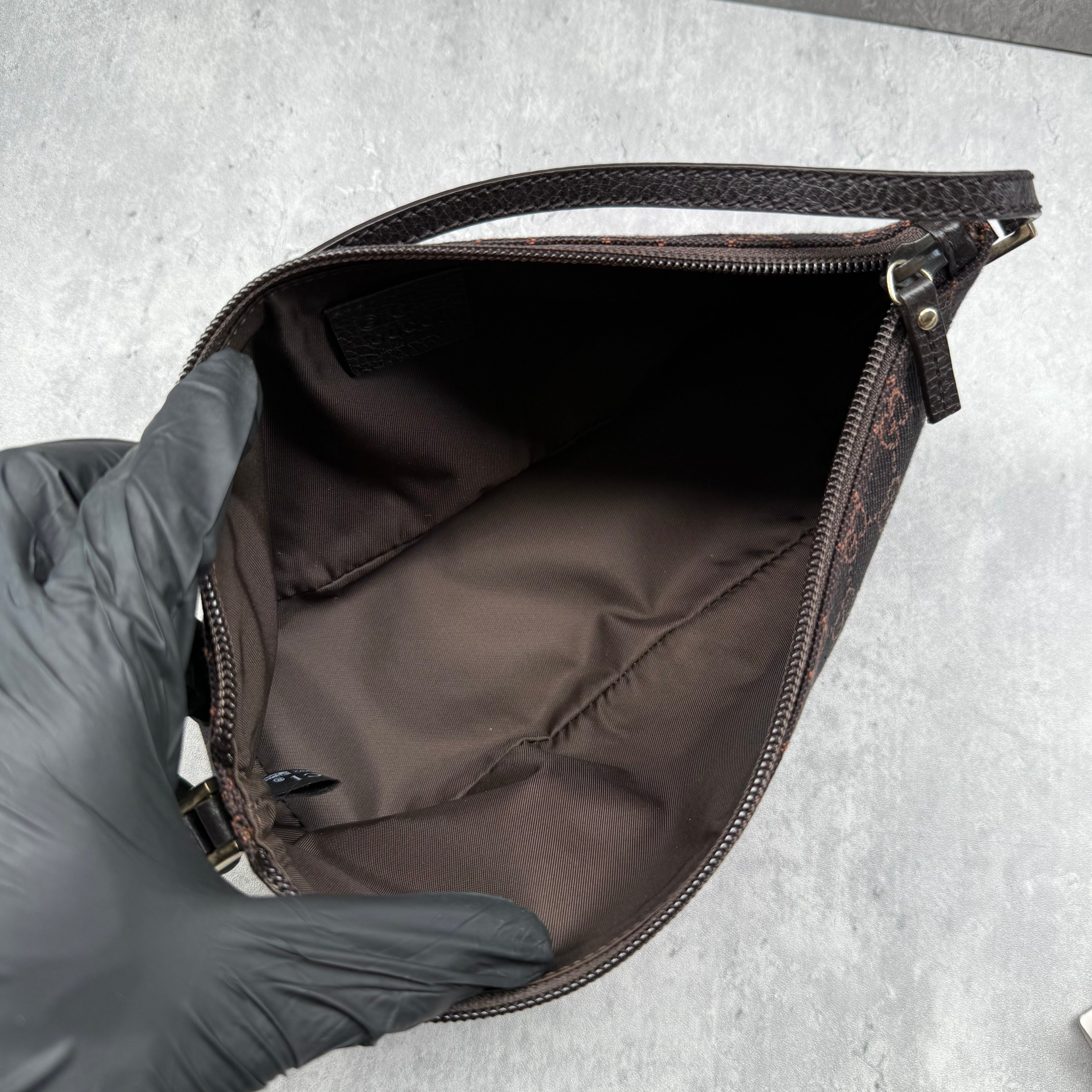 Gucci GG Monogram Pochette Boat Shoulder Bag in black canvas with tonal trim, top zip closure, and minimalist silhouette.