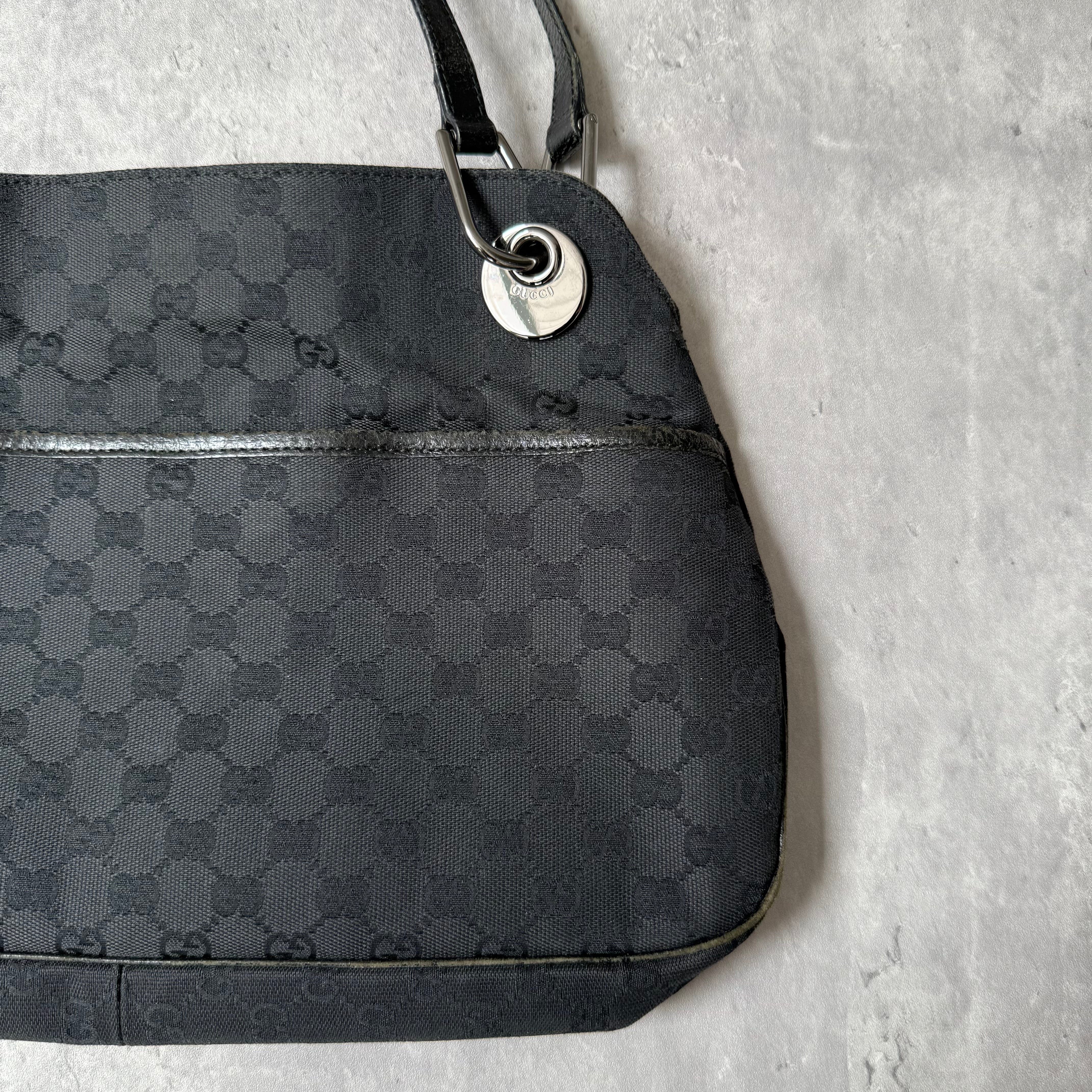 Gucci GG Monogram Shoulder Bag in black canvas with leather trim, silver-tone grommets, and spacious interior.