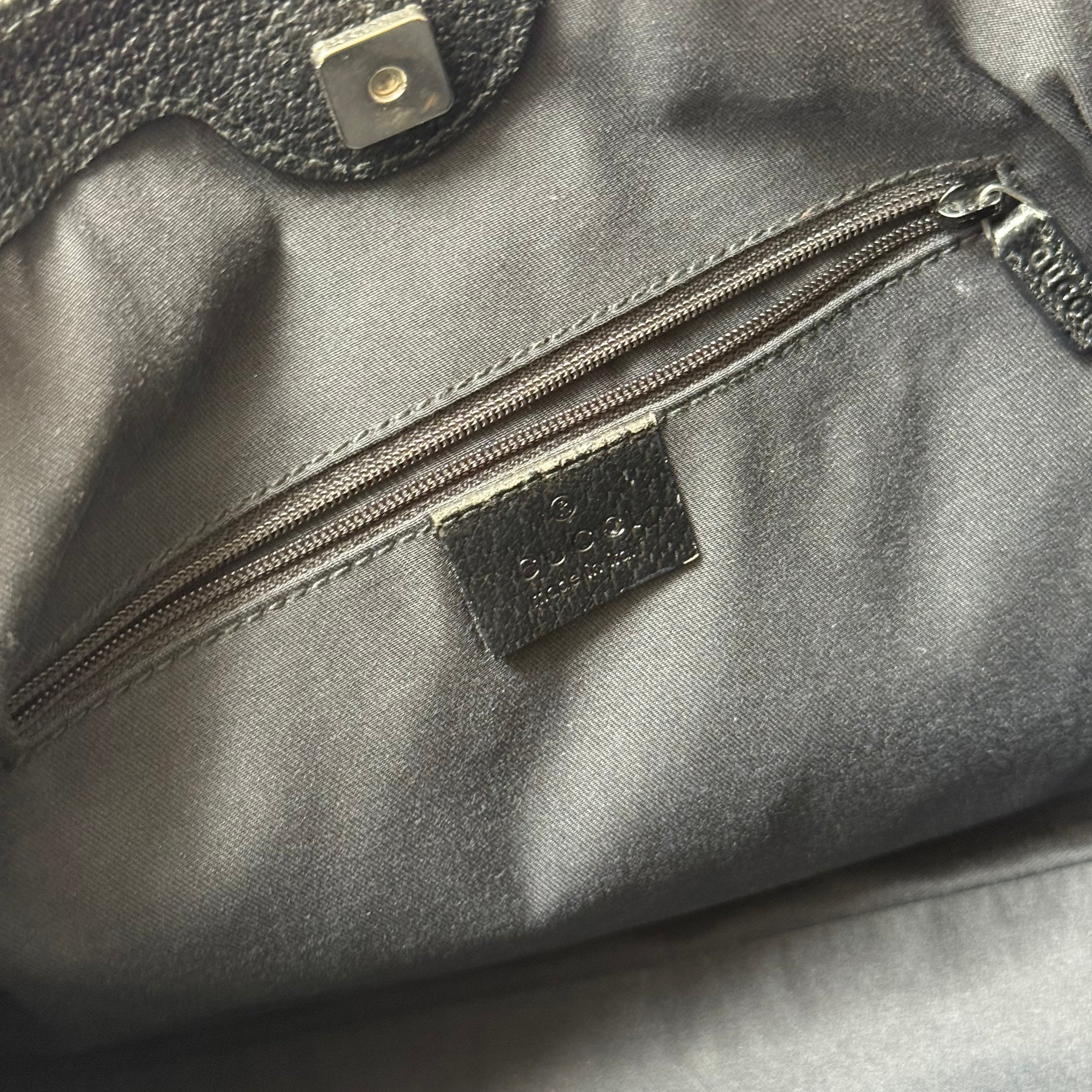 Gucci GG Monogram Shoulder Bag in black canvas with leather trim, silver-tone grommets, and spacious interior.