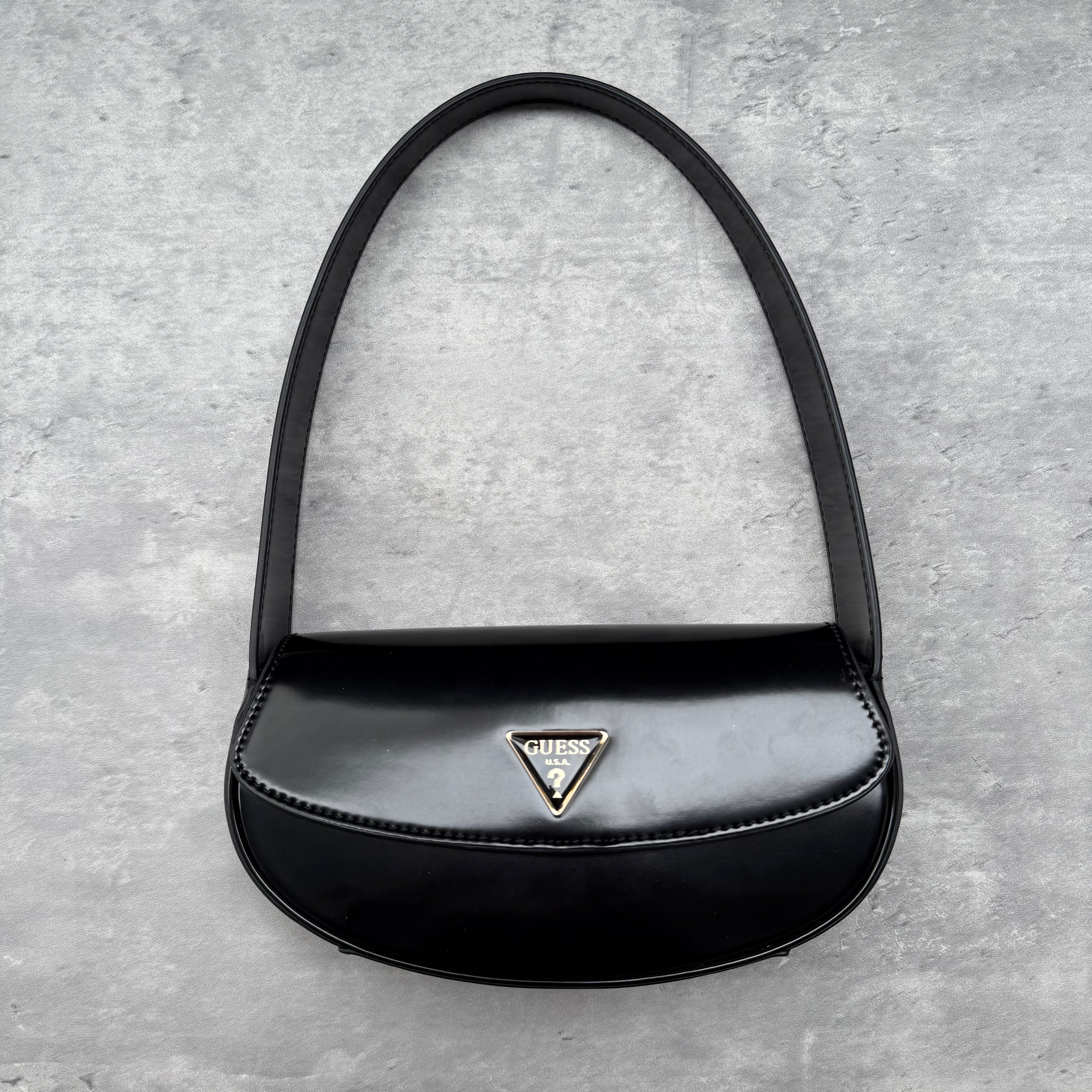 Guess USA Mini Arnela Shoulder Bag in glossy black faux leather with silver-tone triangle logo, flap closure, and single shoulder strap.