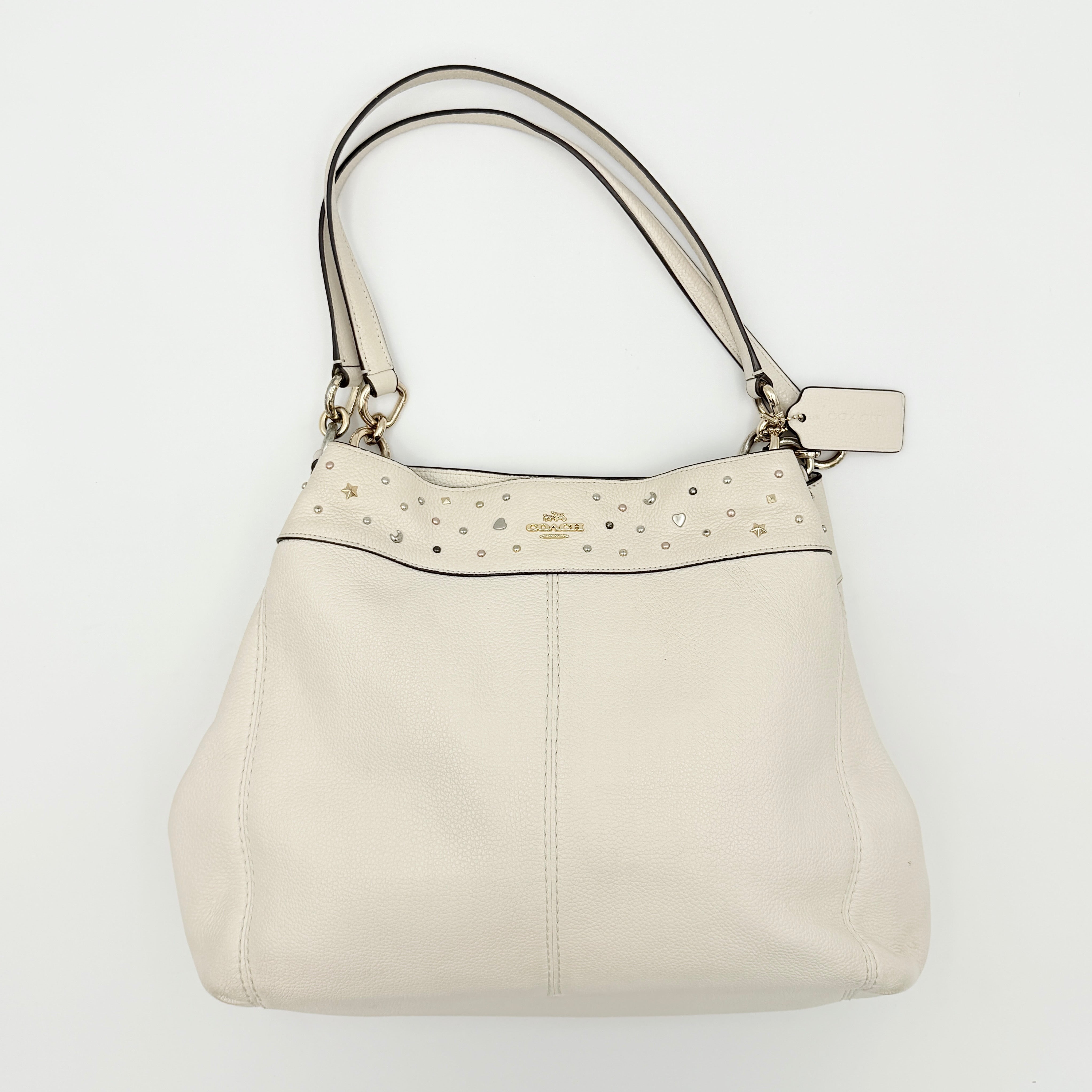 Coach Lexy Stardust Studded Chalk Hobo in ivory pebbled leather, adorned with mixed metal studs and dual handles.