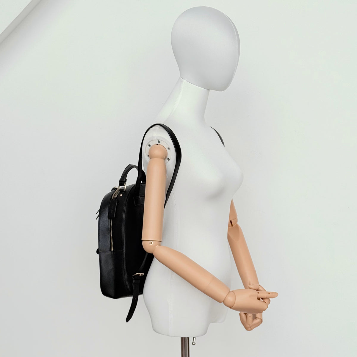 Coach Jordyn Leather Backpack in black grained leather with gold-tone hardware and minimal branding, photographed on white background.