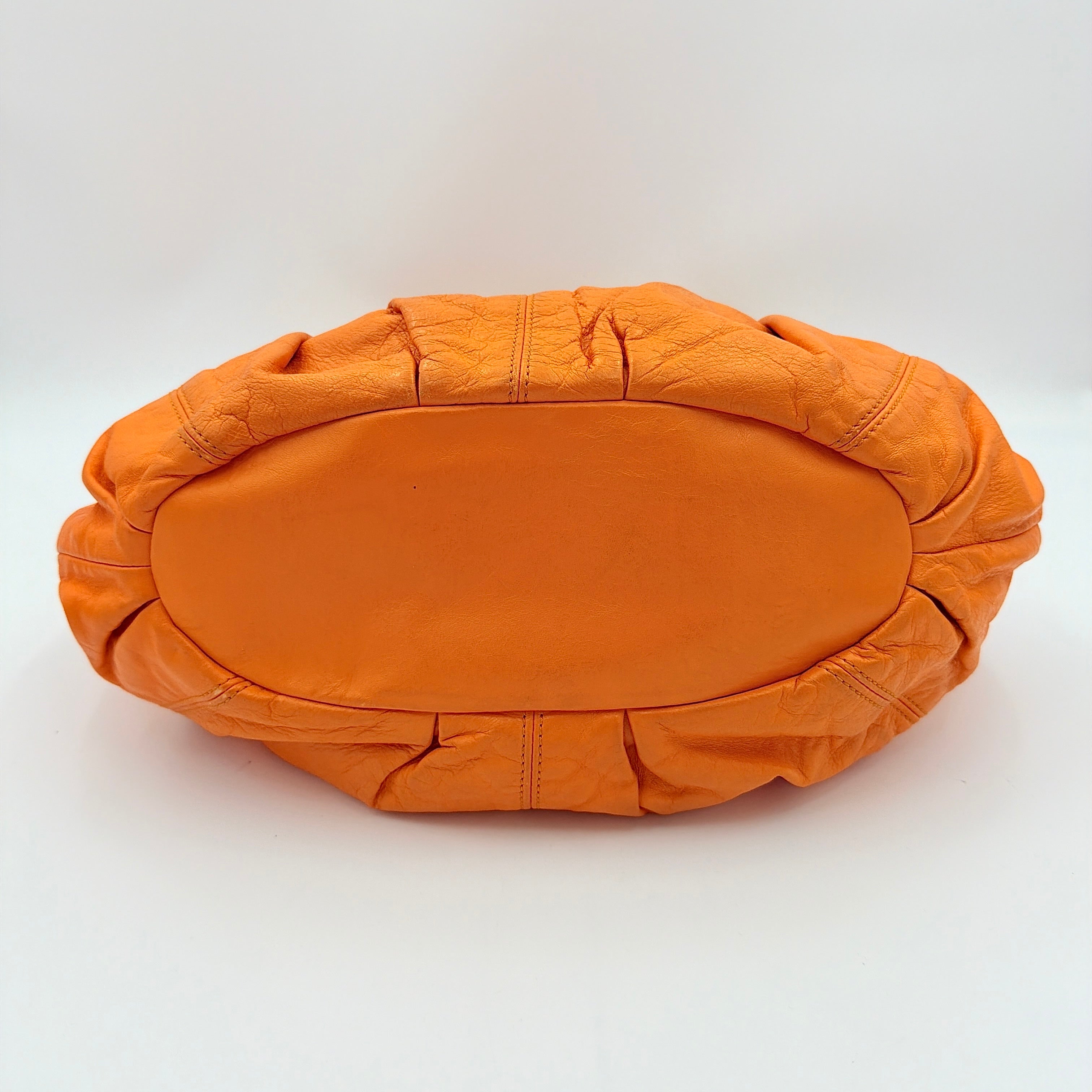 Celine 2Way Shoulder Bag in vibrant orange leather with silver-tone hardware and pleated detailing, shown with both top handles and an adjustable strap.