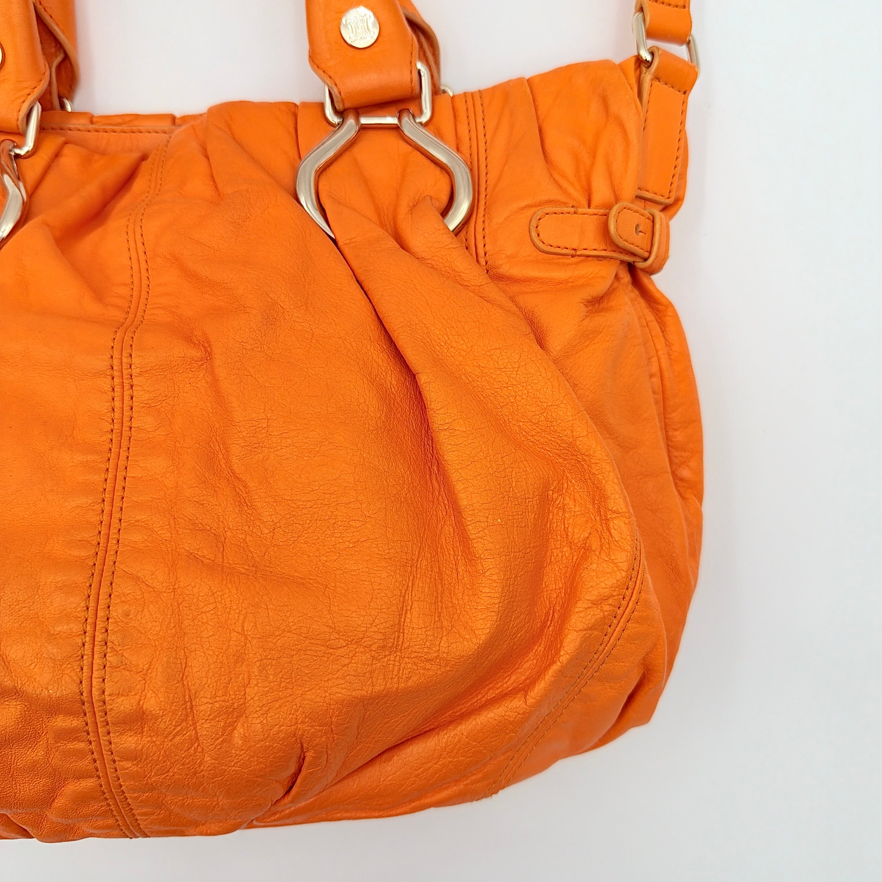 Celine 2Way Shoulder Bag in vibrant orange leather with silver-tone hardware and pleated detailing, shown with both top handles and an adjustable strap.