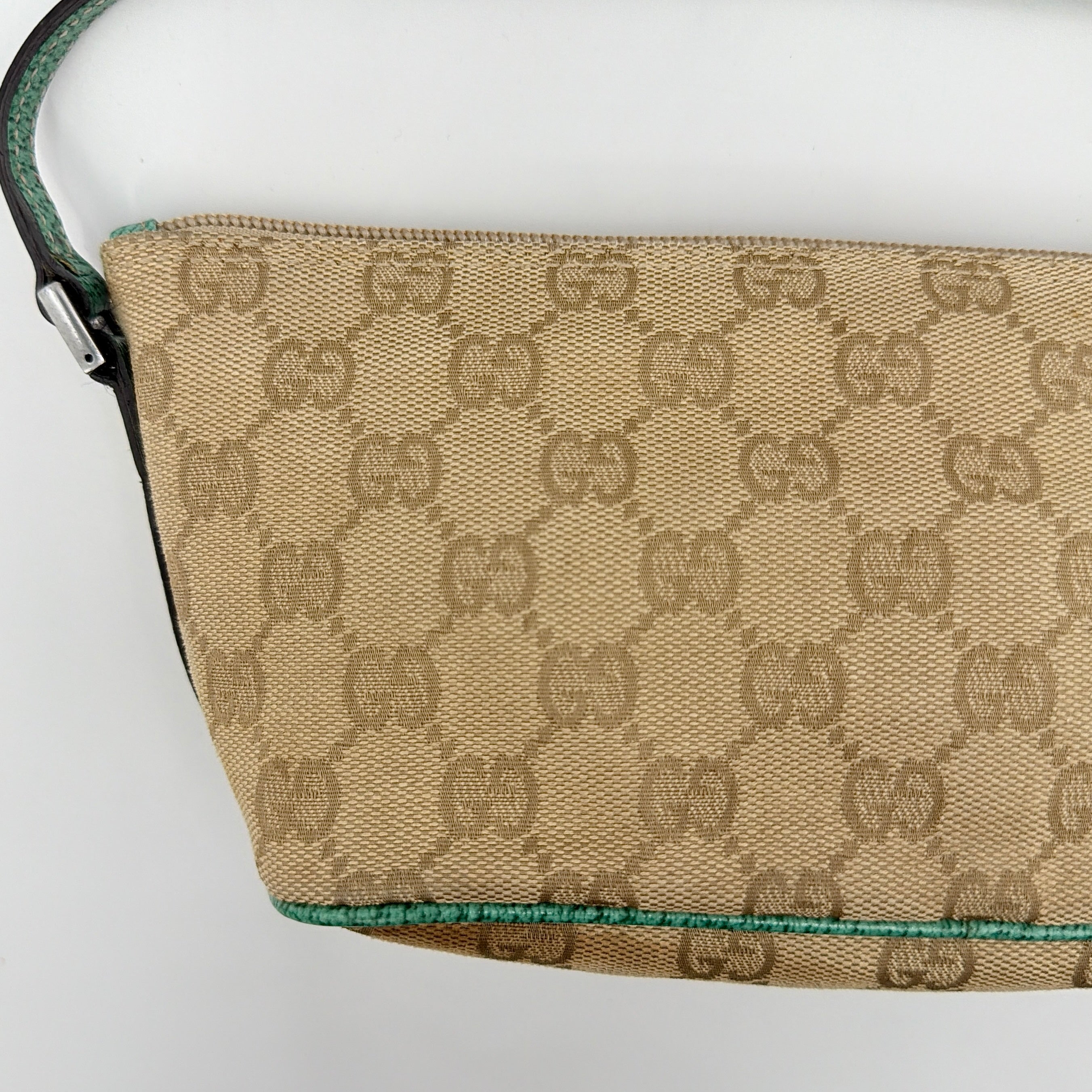 Gucci GG Monogram Pochette Boat Shoulder Bag in beige canvas with green leather trim and a structured, boat-shaped silhouette.