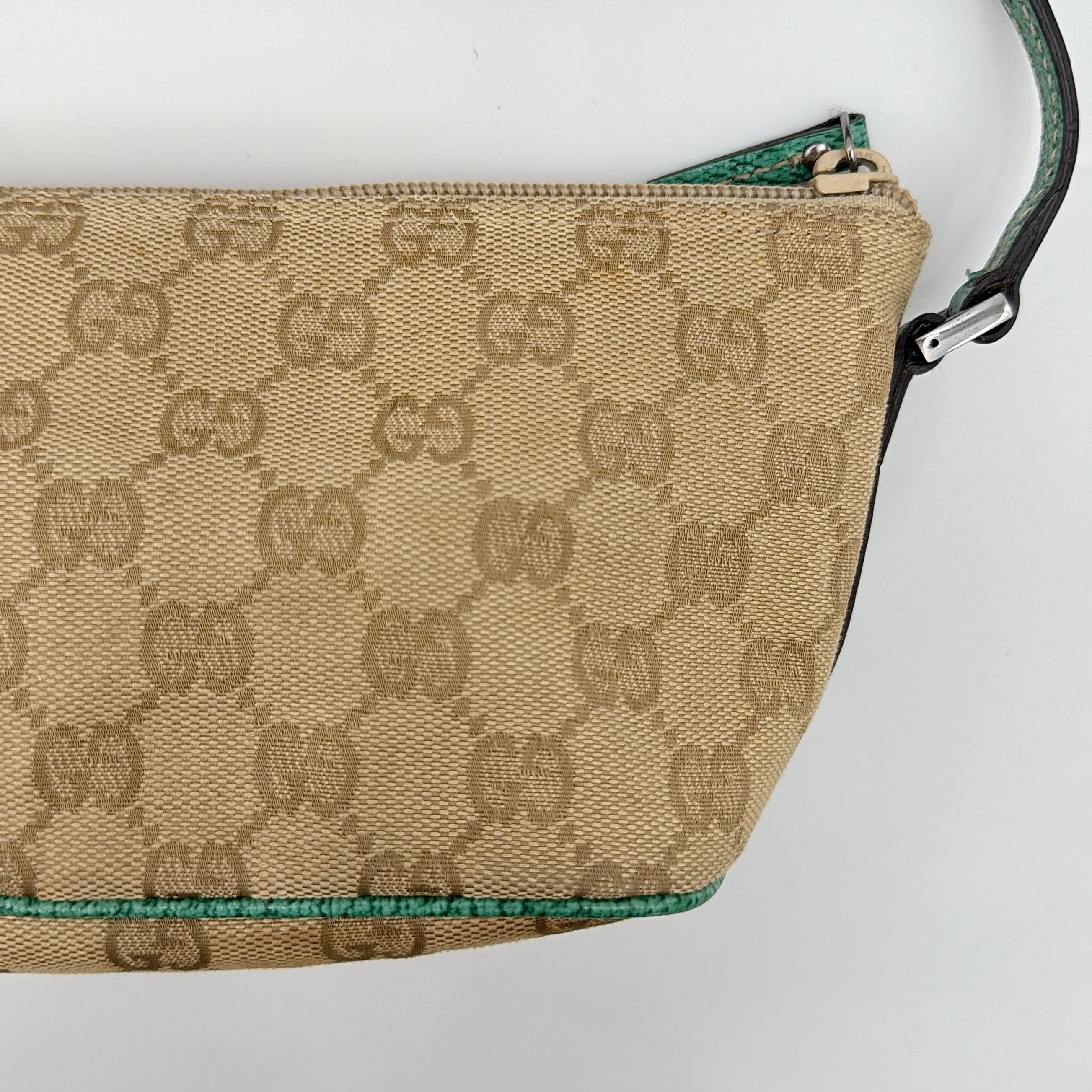 Gucci GG Monogram Pochette Boat Shoulder Bag in beige canvas with green leather trim and a structured, boat-shaped silhouette.