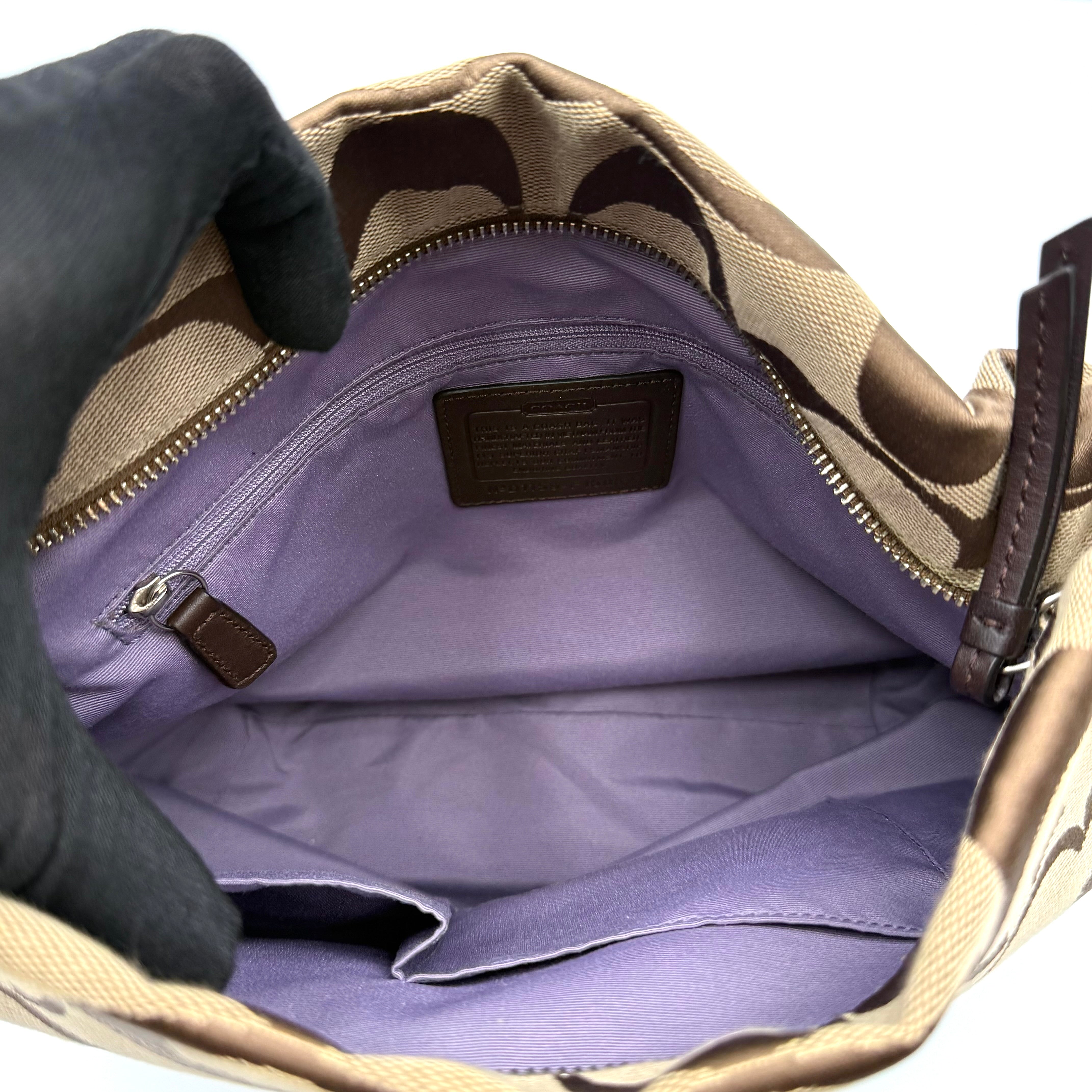 Coach beige and brown signature canvas hobo shoulder bag with black leather strap and silver hardware shown on a white background.