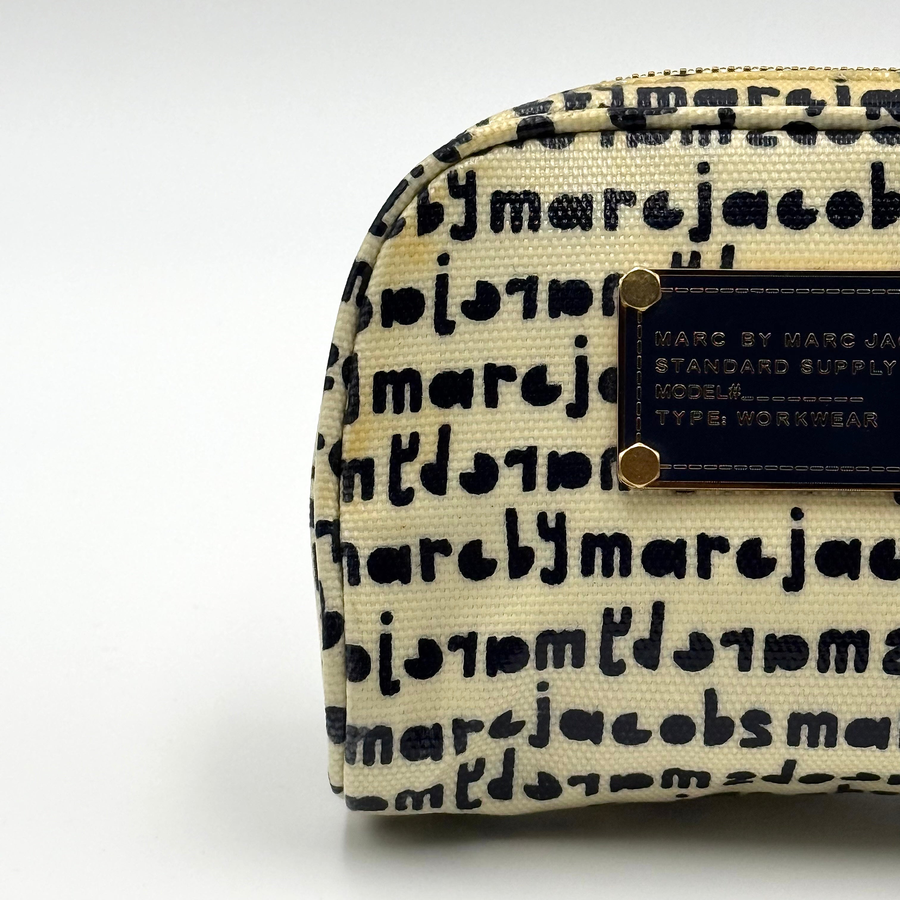 Marc Jacobs dome-shaped cosmetic case in cream coated canvas with navy script and gold hardware.