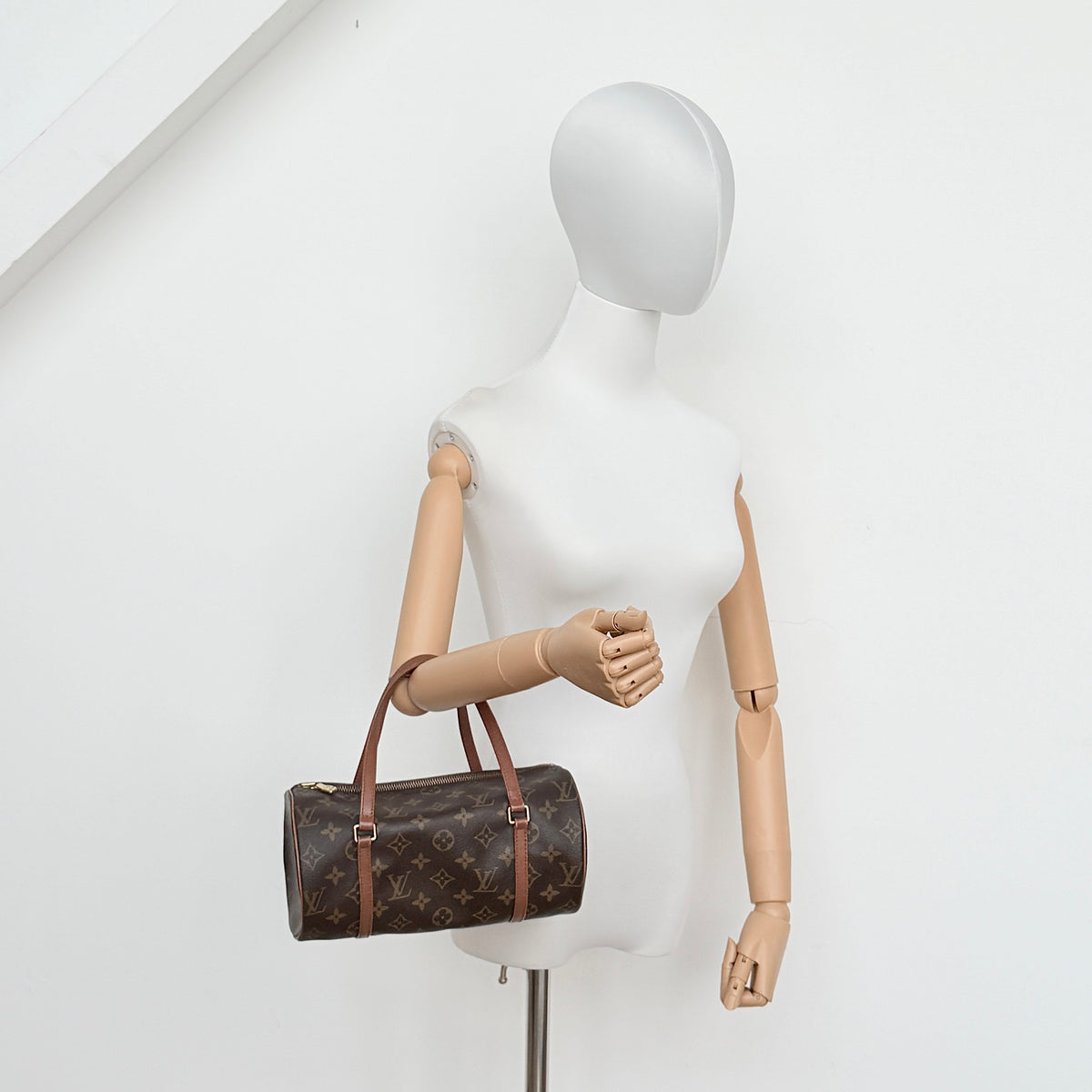 Louis Vuitton Papillon 26 in monogram canvas with leather handles and gold zipper, shown on a white background.