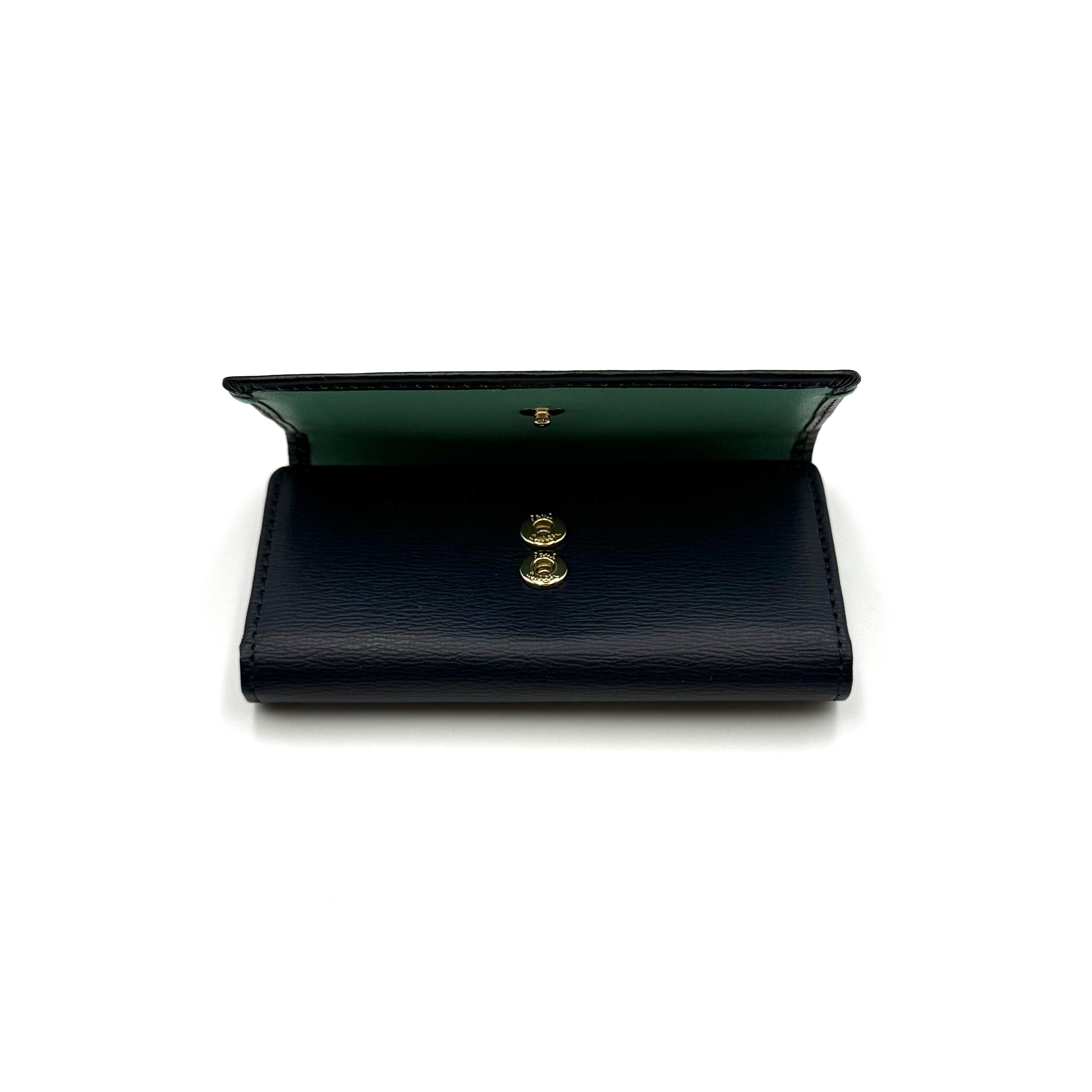 Paul Smith key case in grained black leather with Tiffany blue accents and silver logo, displayed on a white background.