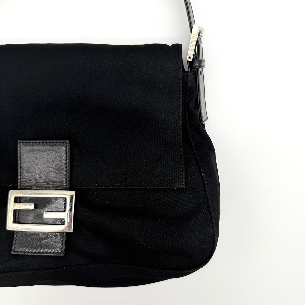 Fendi Mamma Baguette Shoulder Bag in black fabric with silver FF buckle and leather strap, photographed on a white backdrop.