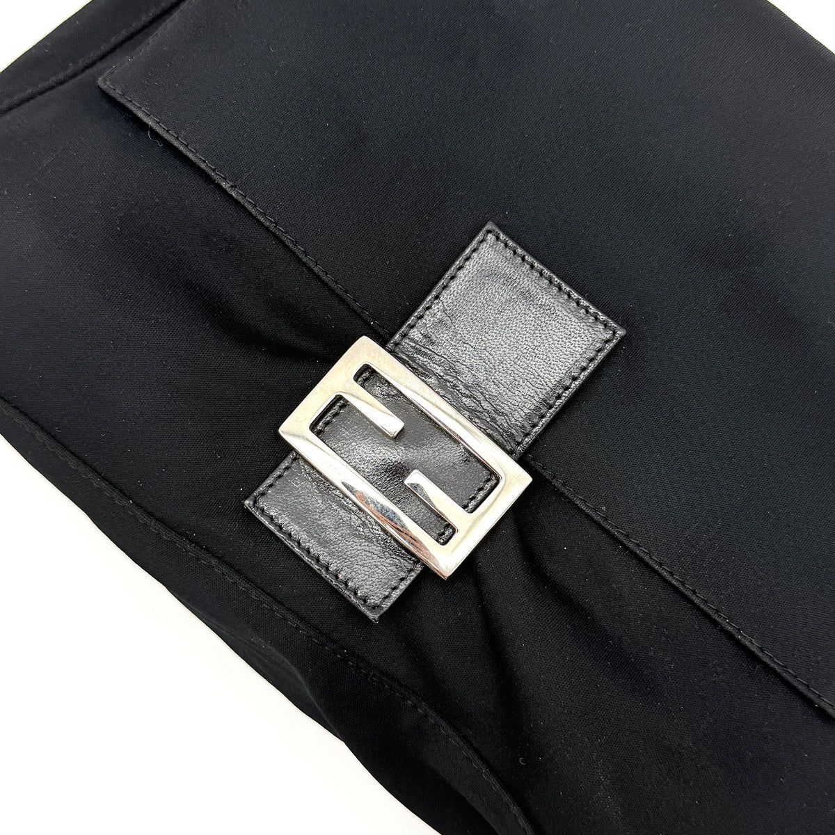 Fendi Mamma Baguette Shoulder Bag in black fabric with silver FF buckle and leather strap, photographed on a white backdrop.