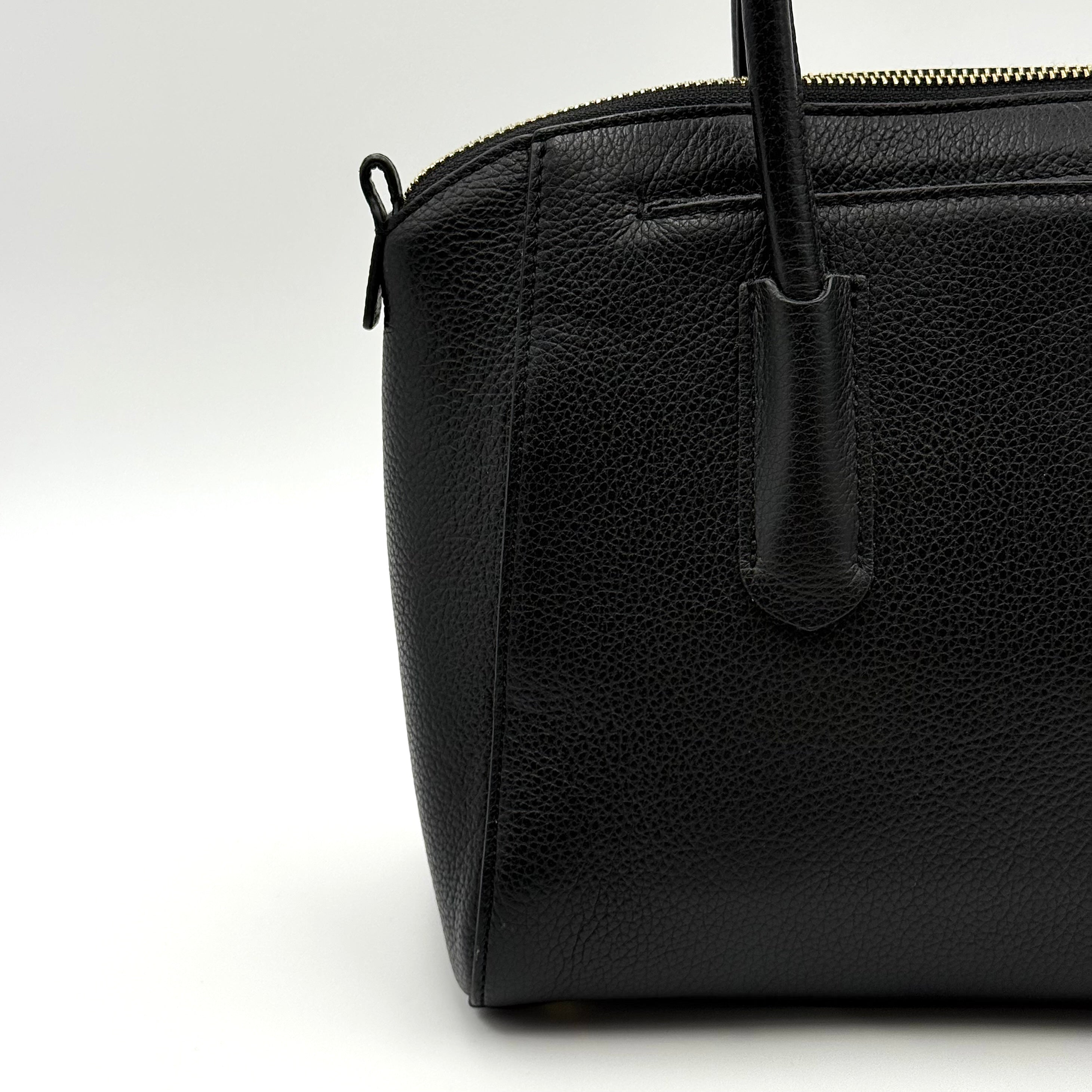 Front view of the Furla Tessa black leather satchel with gold-tone Furla charm and structured silhouette.