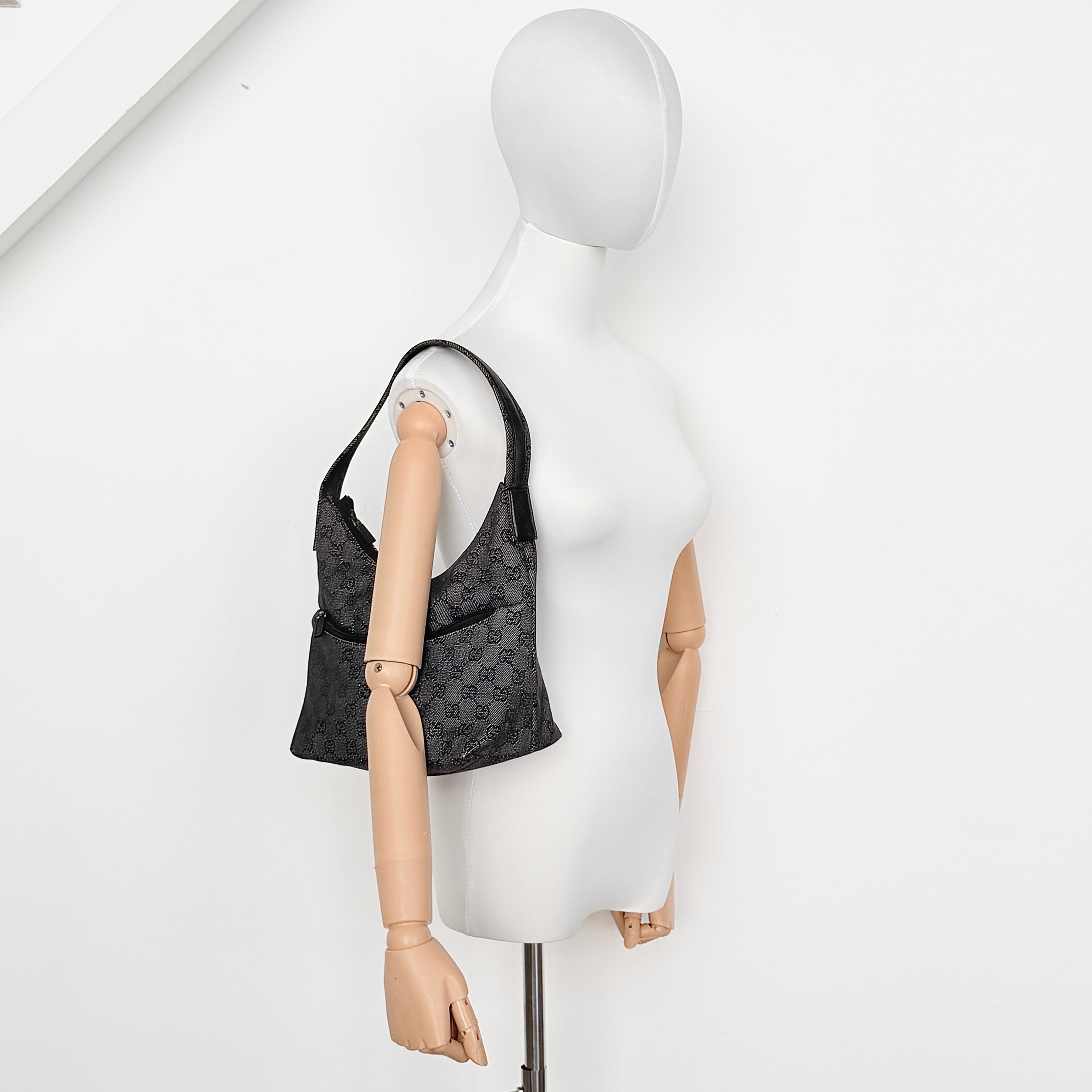 Gucci GG Monogram Hobo Shoulder Bag in black canvas with tonal GG pattern and a curved shoulder strap, photographed on a white background.