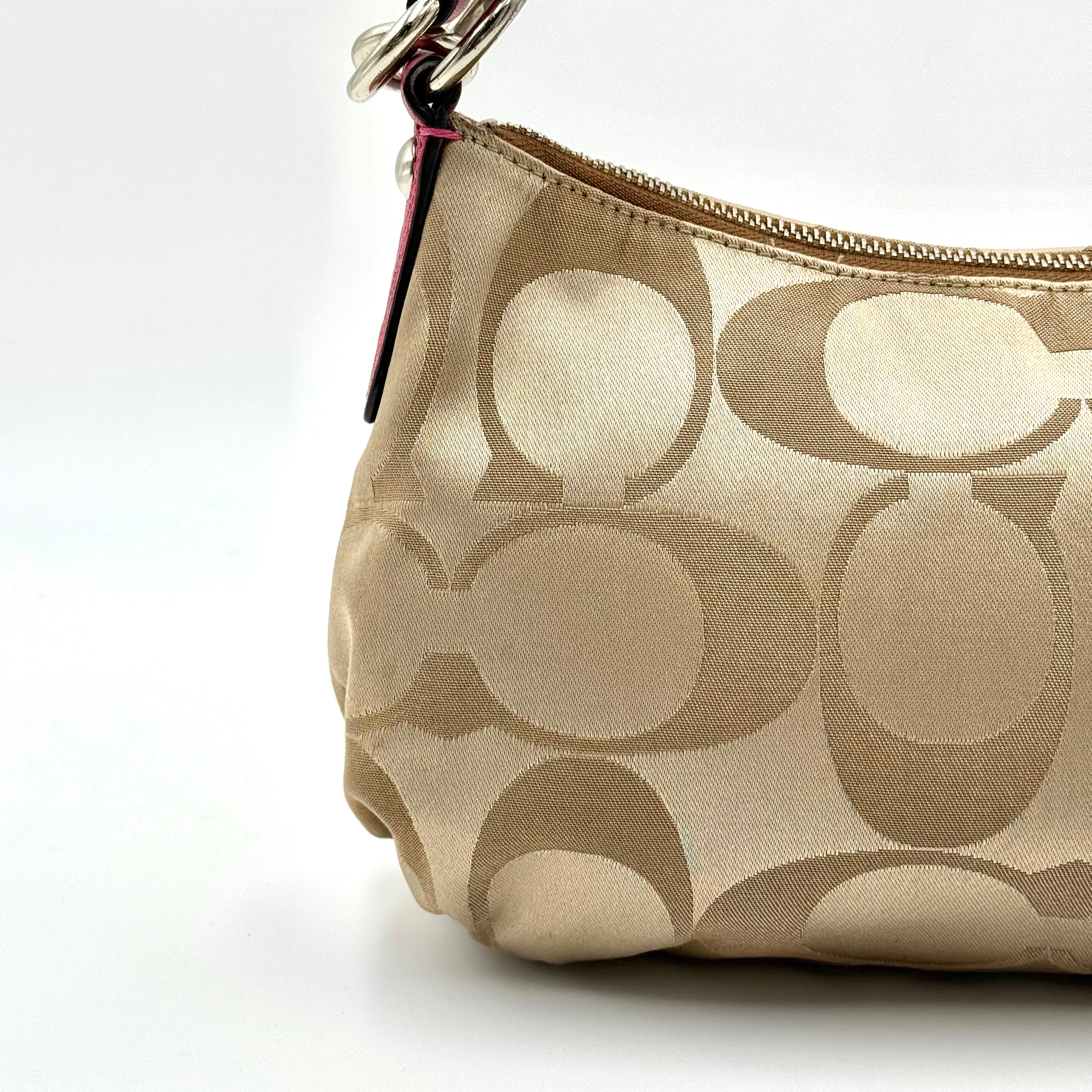 Coach Signature Poppy Sateen Groovy Shoulder Bag in beige with pink trim and detachable strap, displayed on a white background.