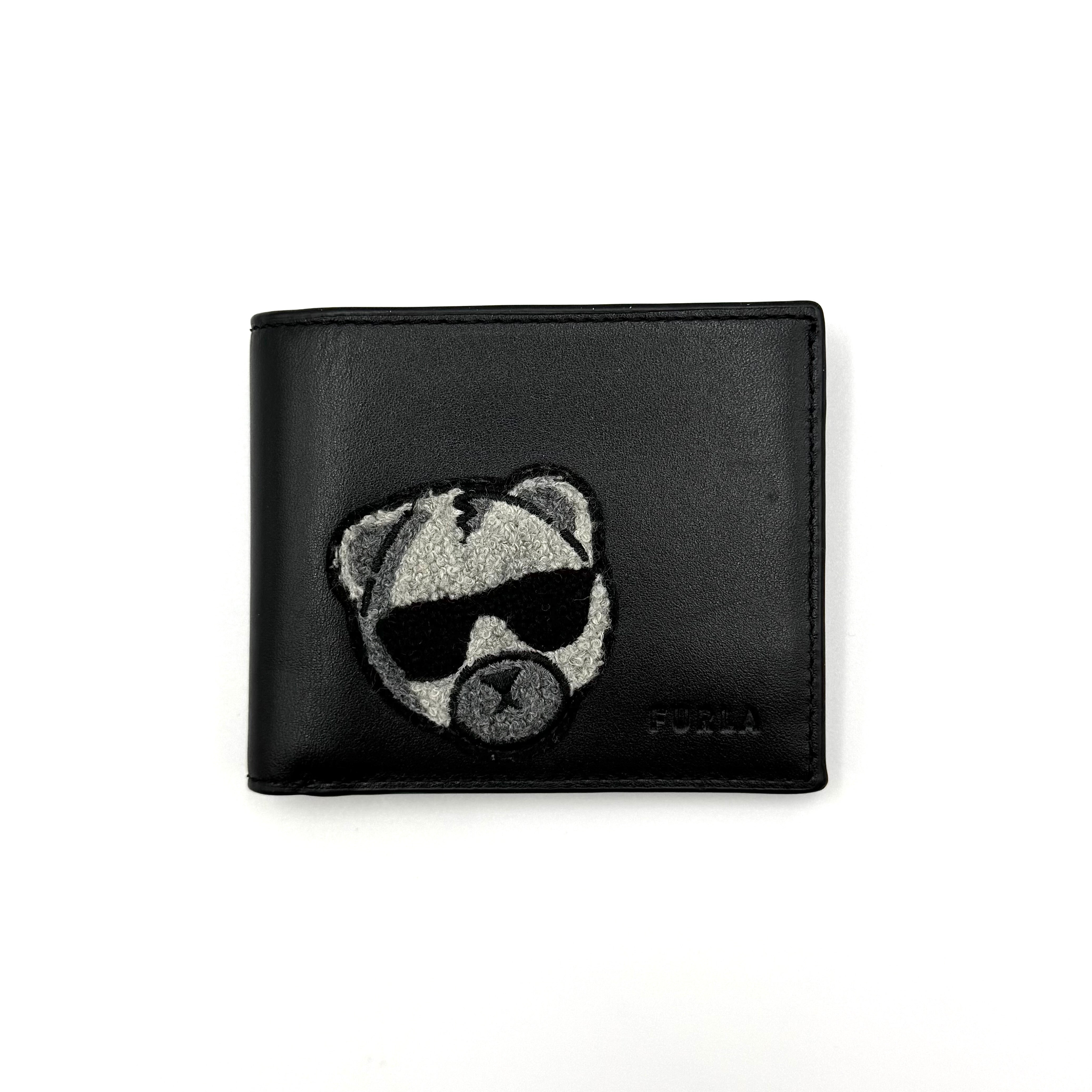 Furla Man Cosmo black leather bifold wallet with a textured teddy bear patch on the front.