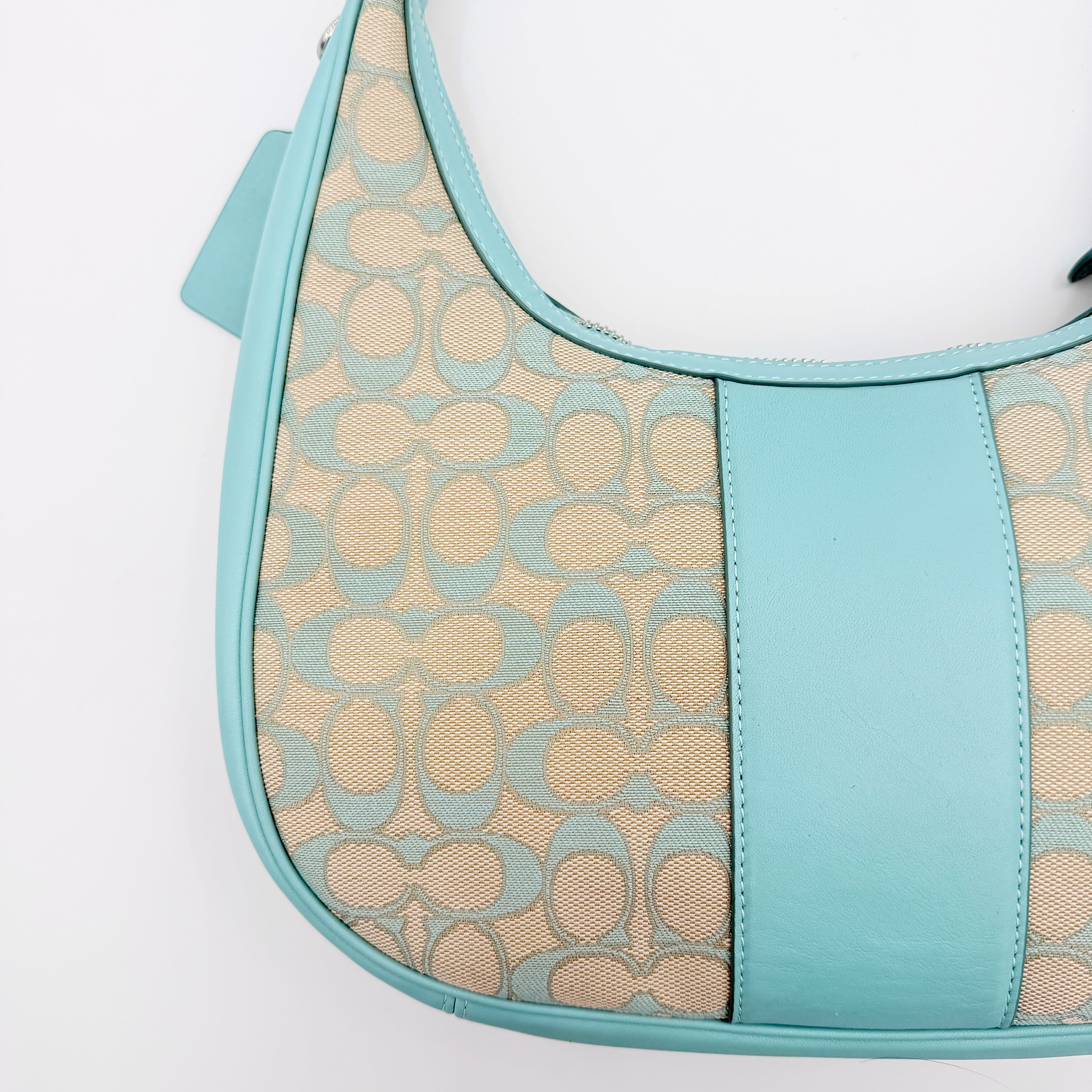 Coach Signature Carmen Shoulder Bag in beige and blue canvas with powder blue leather trim and silver hardware, photographed on white background.