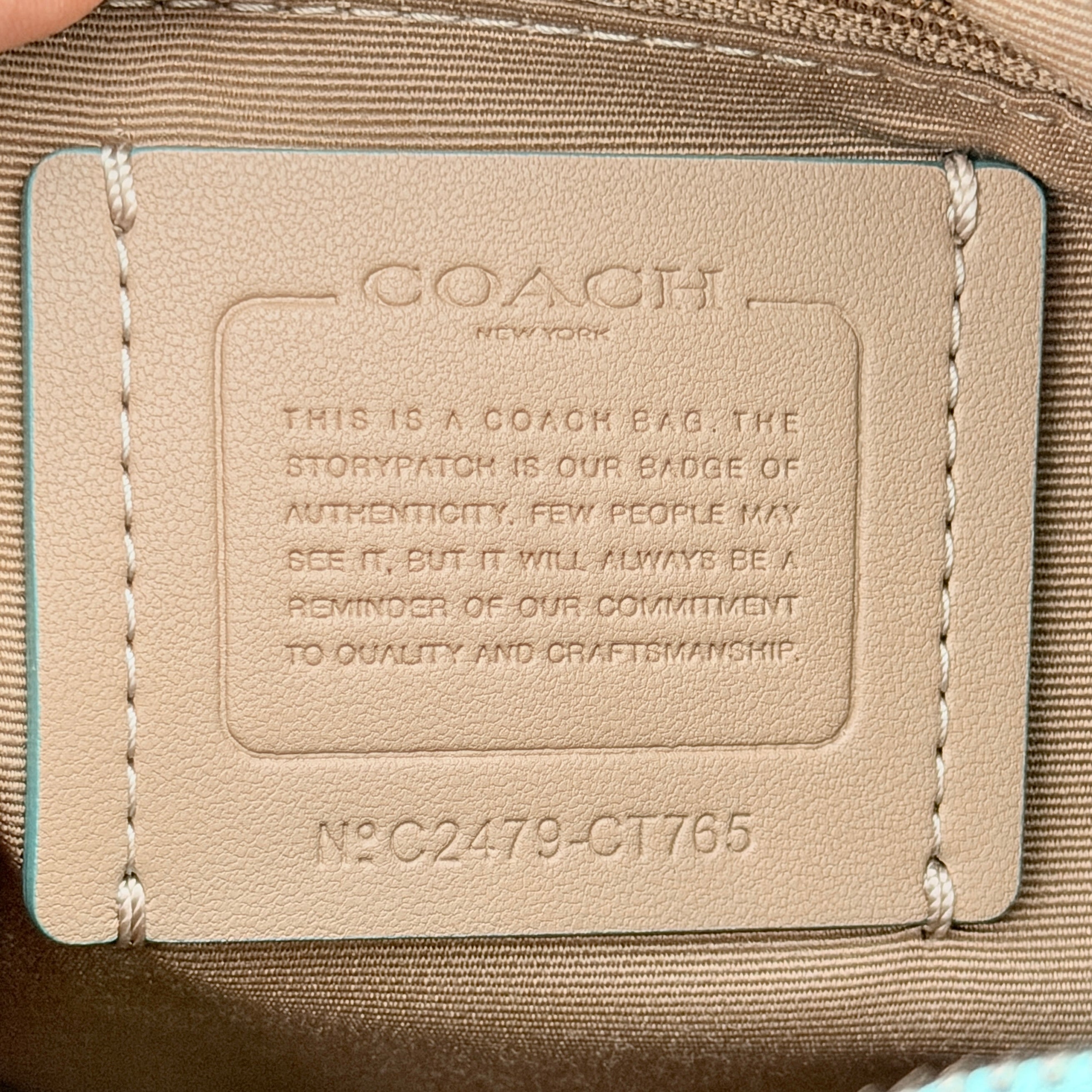 Coach Signature Carmen Shoulder Bag in beige and blue canvas with powder blue leather trim and silver hardware, photographed on white background.