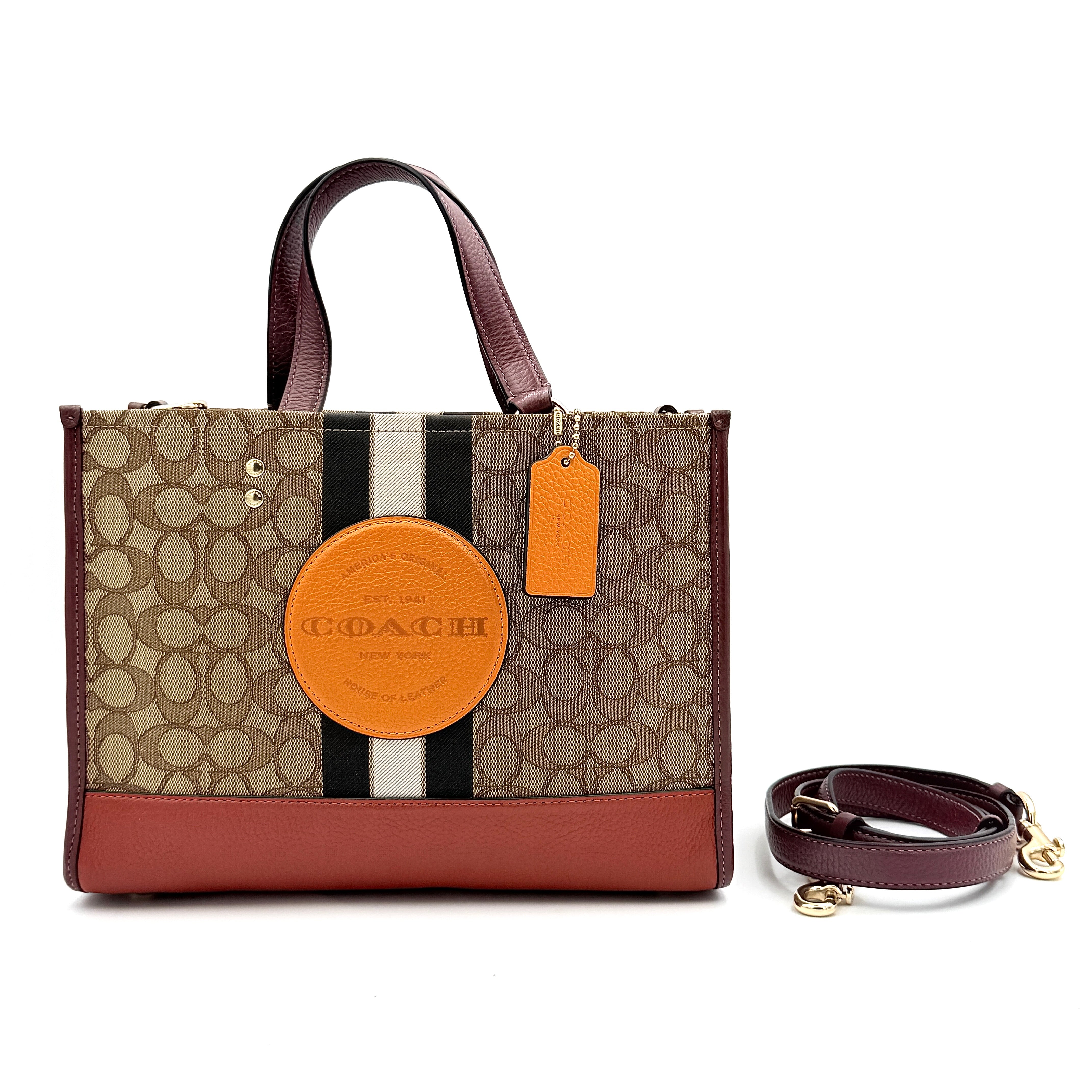 Coach 2Way Signature 22 Dempsey Tote in brown jacquard and burgundy leather with orange logo patch, shown with detachable strap.