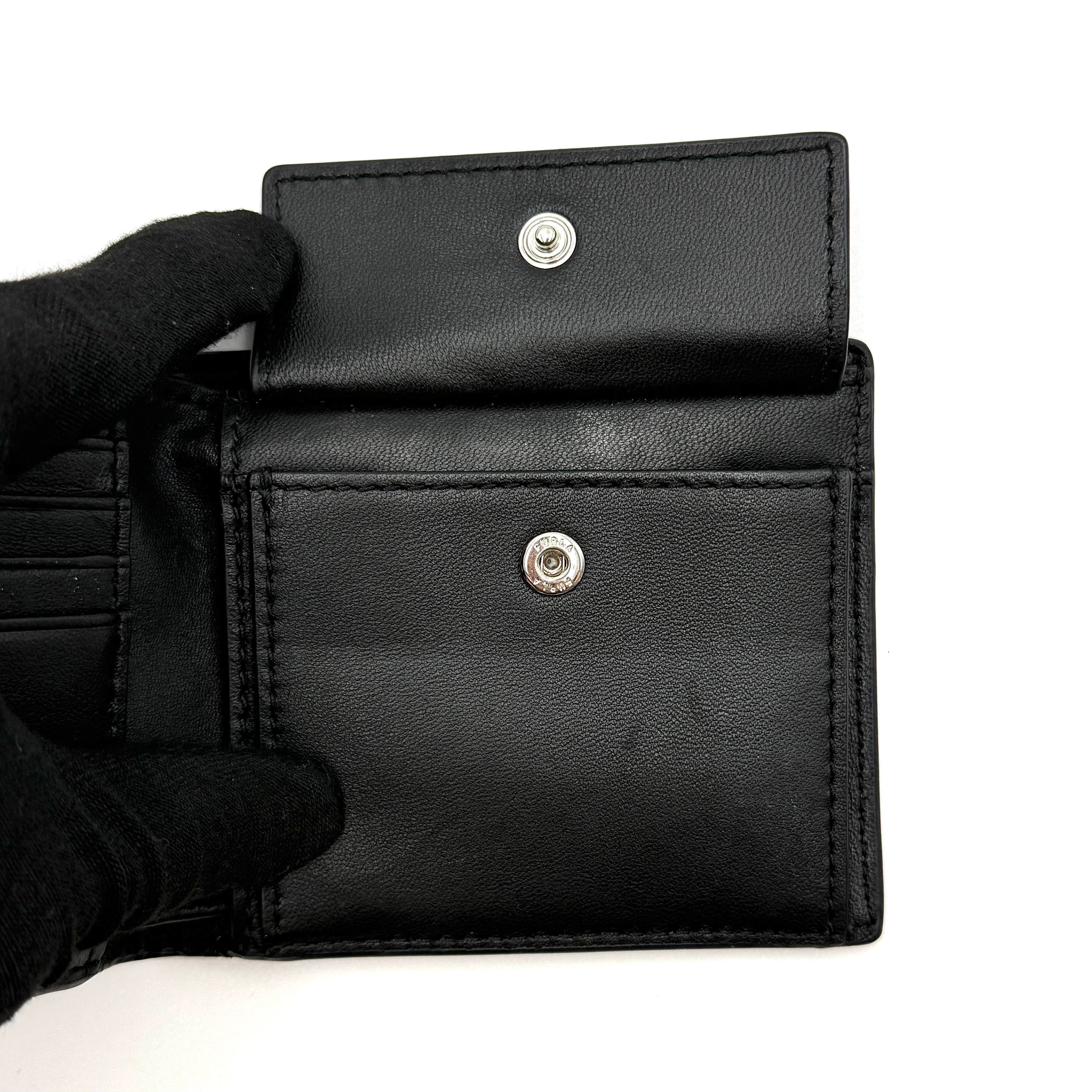 Furla Man Cosmo black leather bifold wallet with a textured teddy bear patch on the front.