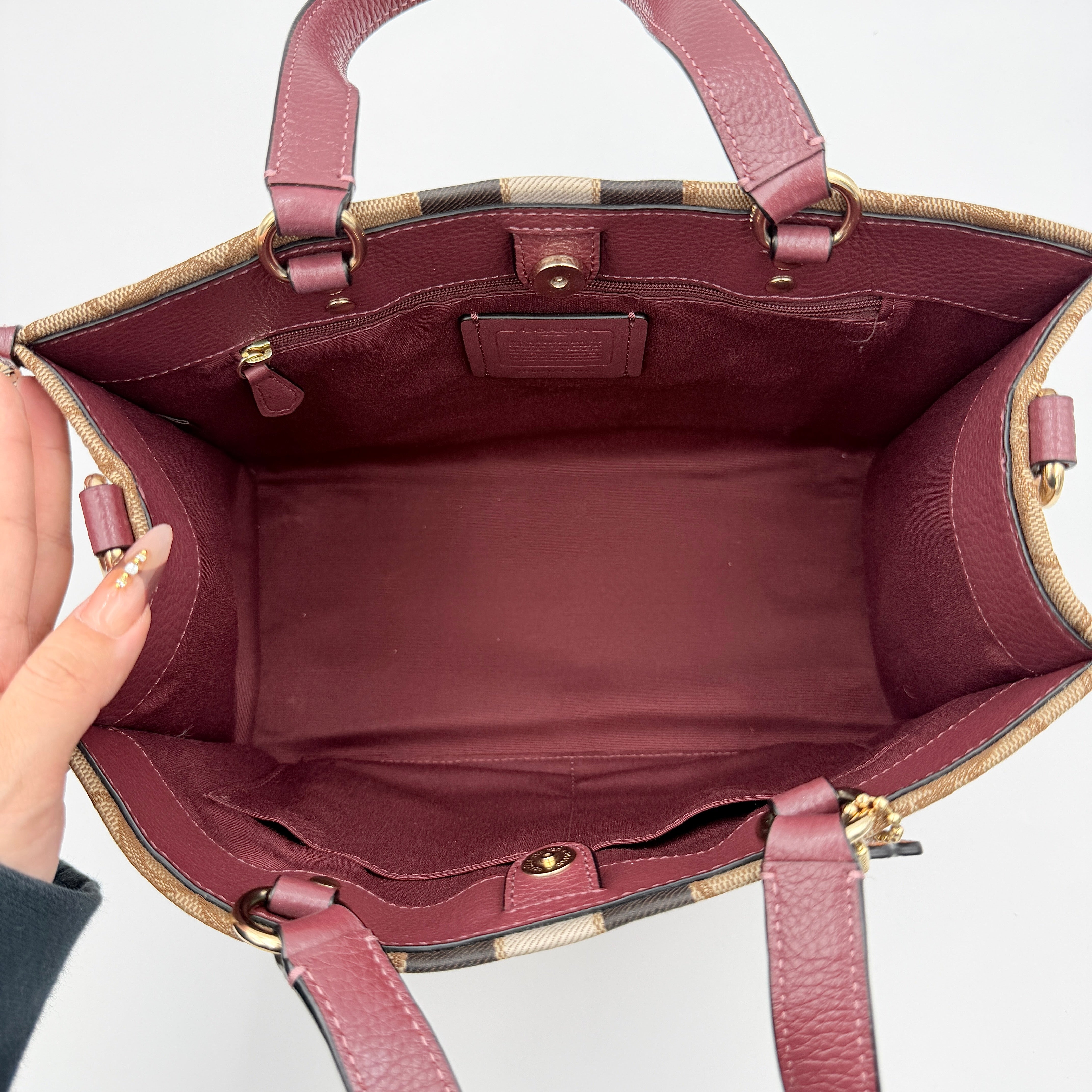 Coach 2Way Signature 22 Dempsey Tote in brown jacquard and burgundy leather with orange logo patch, shown with detachable strap.