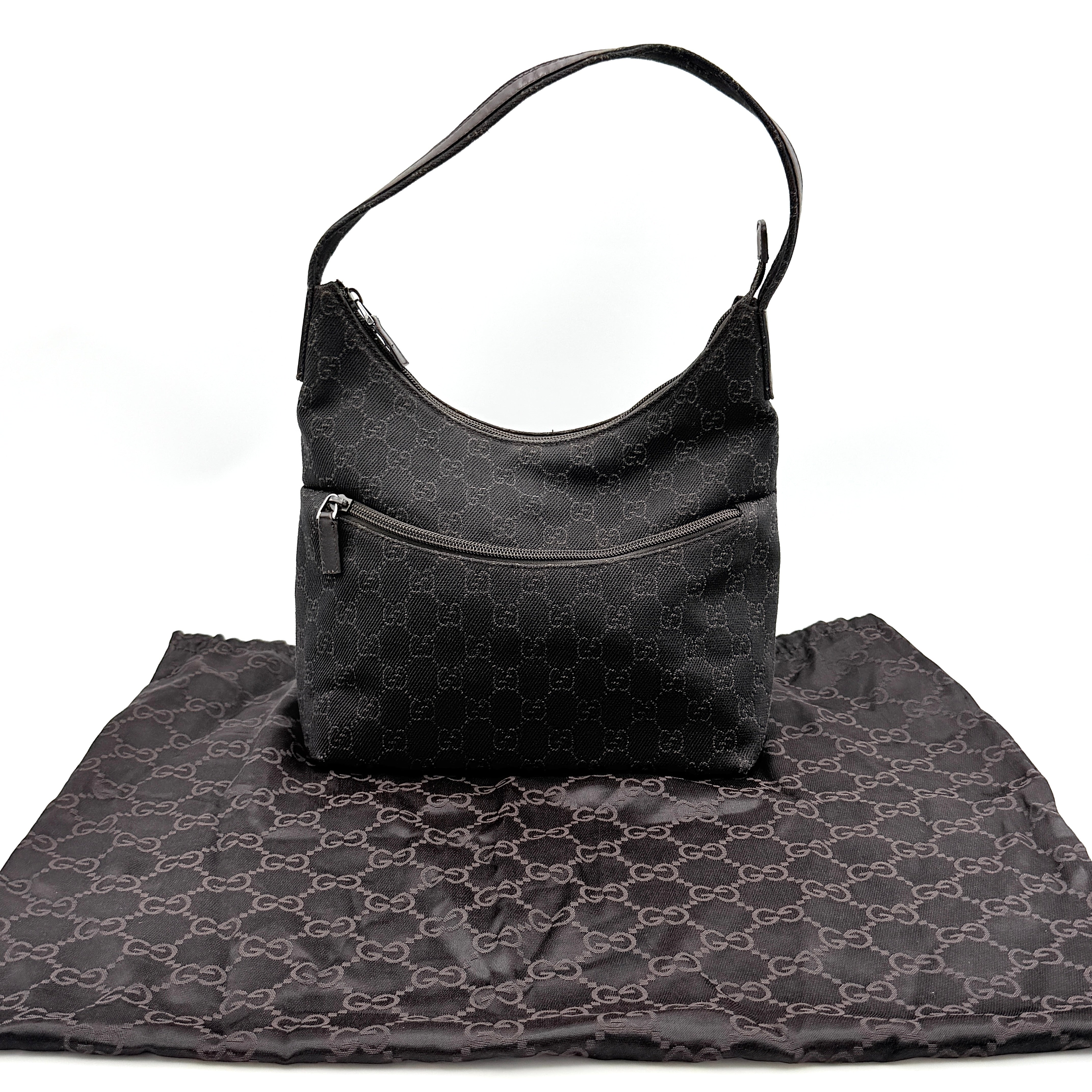 A brown Gucci GG Monogram Hobo Shoulder Bag with a single shoulder strap, styled on a matching GG dust bag.