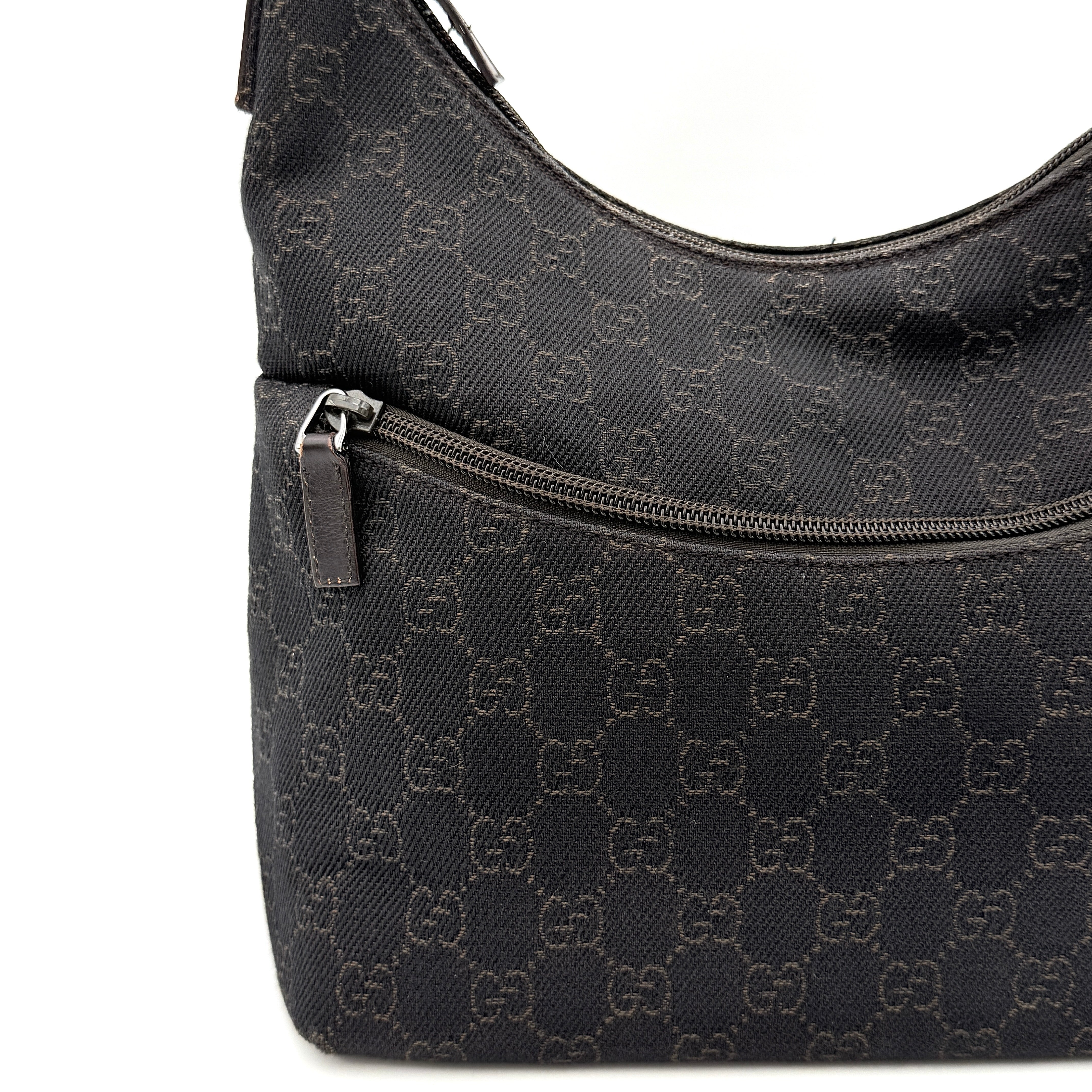 A brown Gucci GG Monogram Hobo Shoulder Bag with a single shoulder strap, styled on a matching GG dust bag.