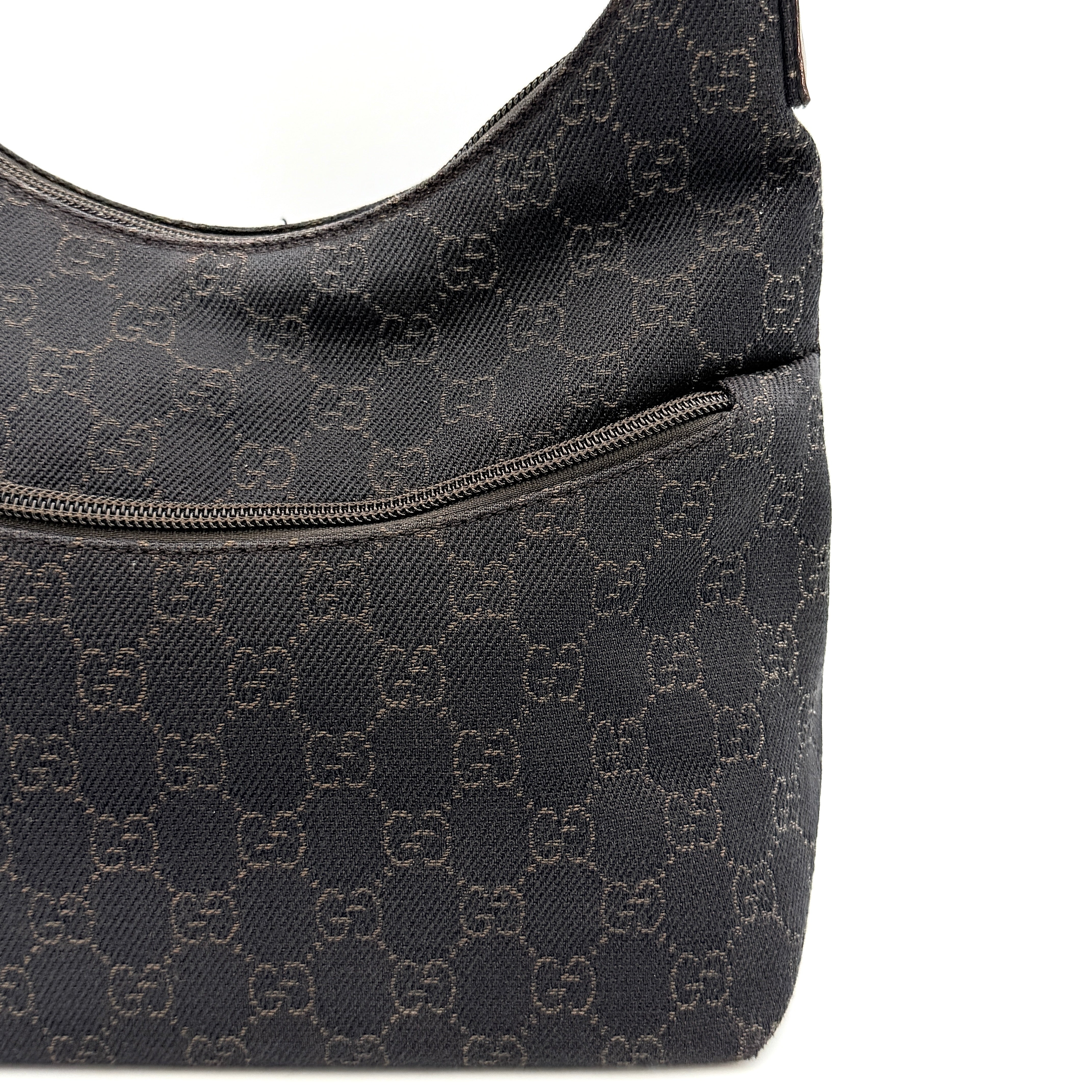 A brown Gucci GG Monogram Hobo Shoulder Bag with a single shoulder strap, styled on a matching GG dust bag.