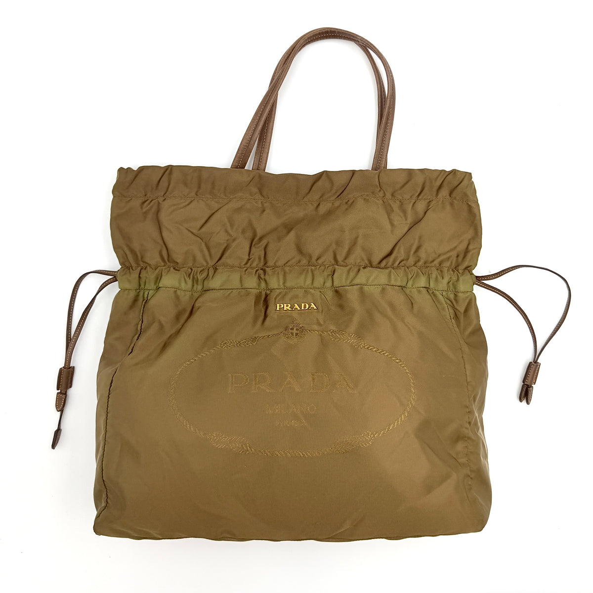 Prada Tessuto brown nylon drawstring shoulder bag with leather handles and gold logo detail, photographed against a white background.