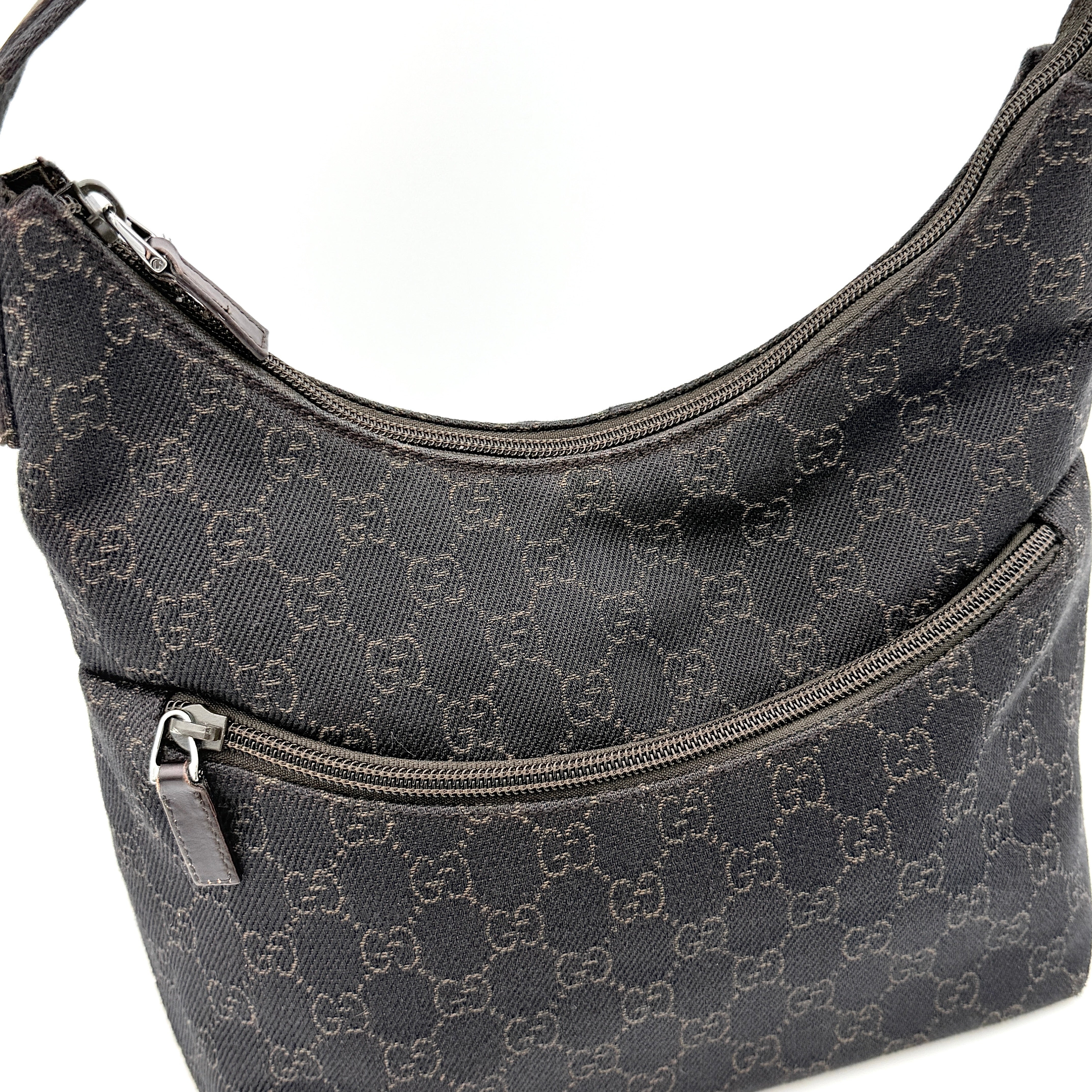 A brown Gucci GG Monogram Hobo Shoulder Bag with a single shoulder strap, styled on a matching GG dust bag.