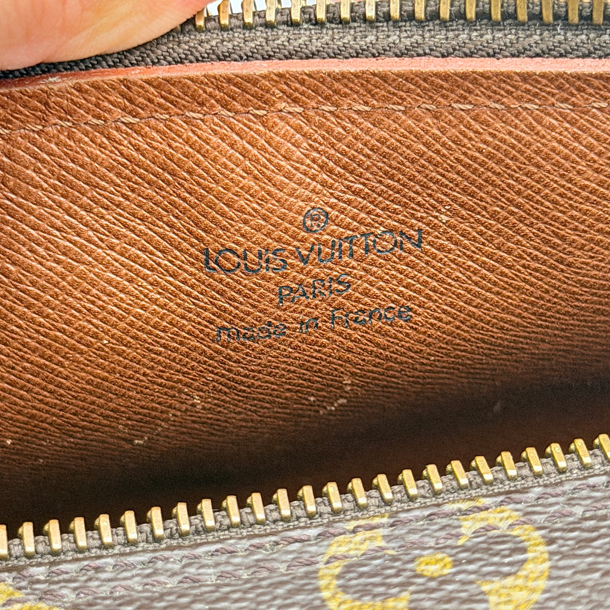 Louis Vuitton Papillon 26 in monogram canvas with leather handles and gold zipper, shown on a white background.
