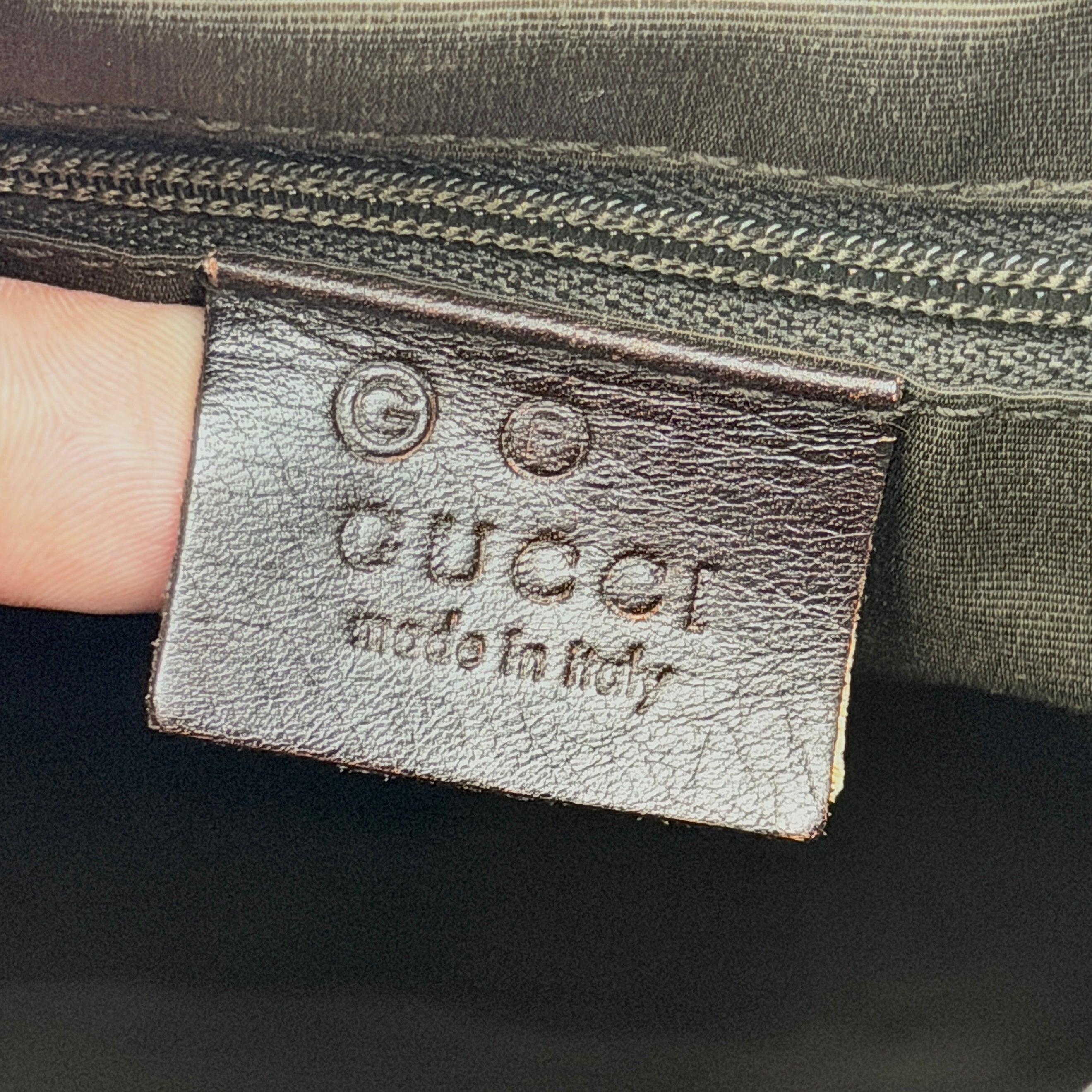 A brown Gucci GG Monogram Hobo Shoulder Bag with a single shoulder strap, styled on a matching GG dust bag.