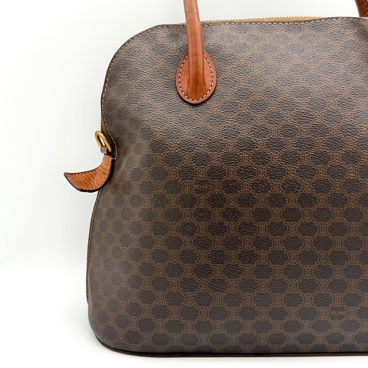 Celine Triomphe Macadam Dome Handbag in brown coated canvas with tan leather handles, shown against a white background.