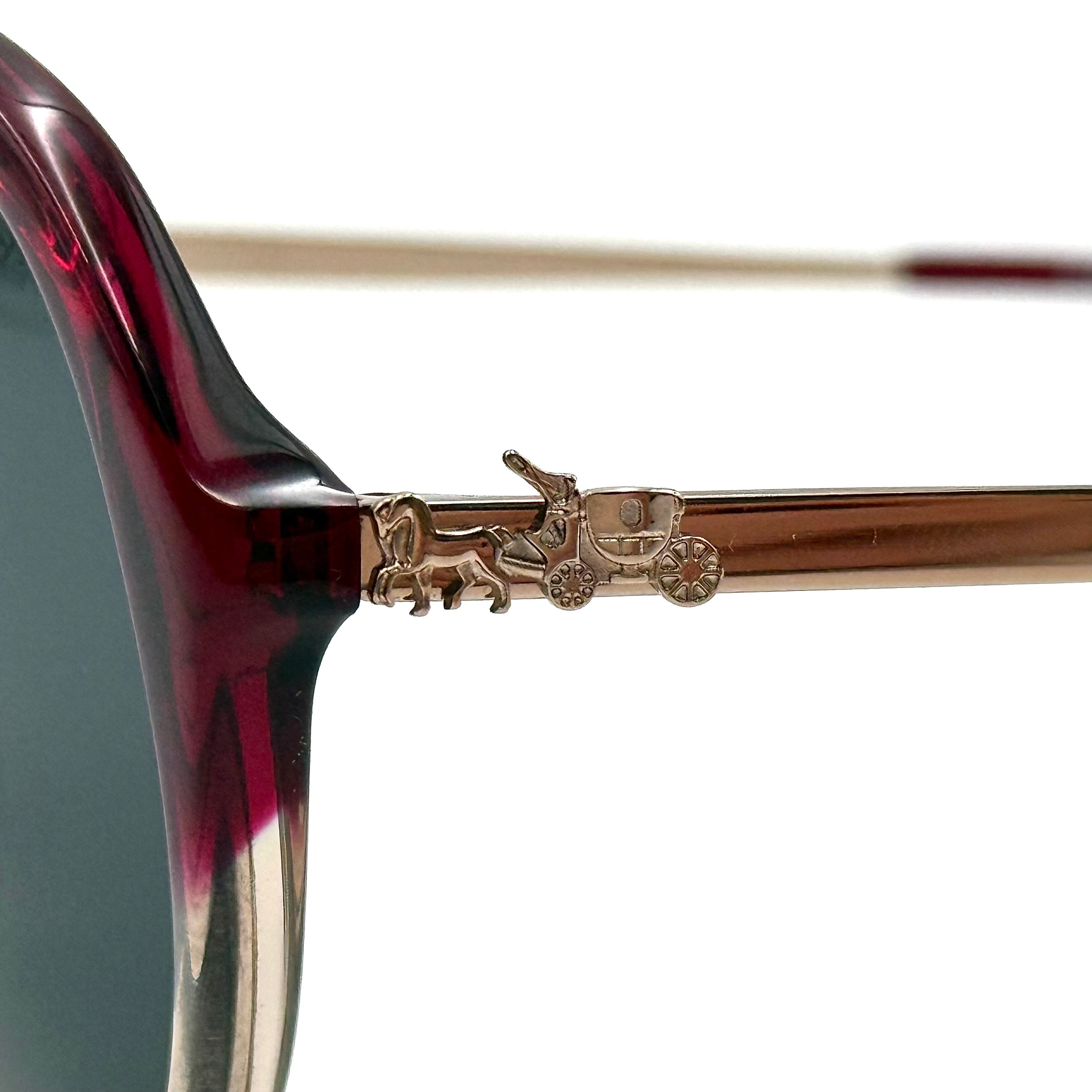 Coach HC8214F sunglasses in a red-to-sand gradient acetate frame with gold-tone metal temples and signature carriage detail.
