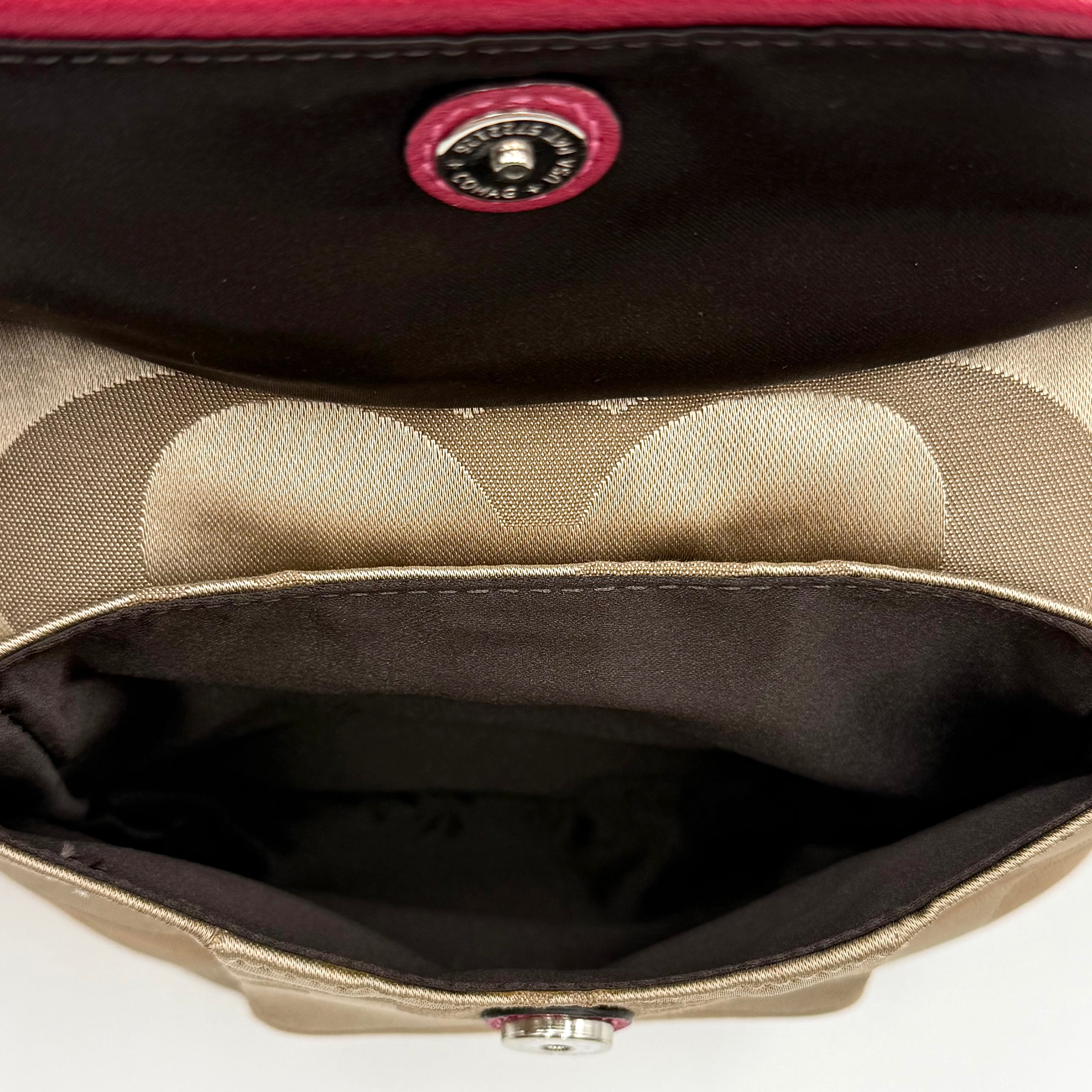 Coach Signature Poppy Sateen Groovy Shoulder Bag in beige with pink trim and detachable strap, displayed on a white background.