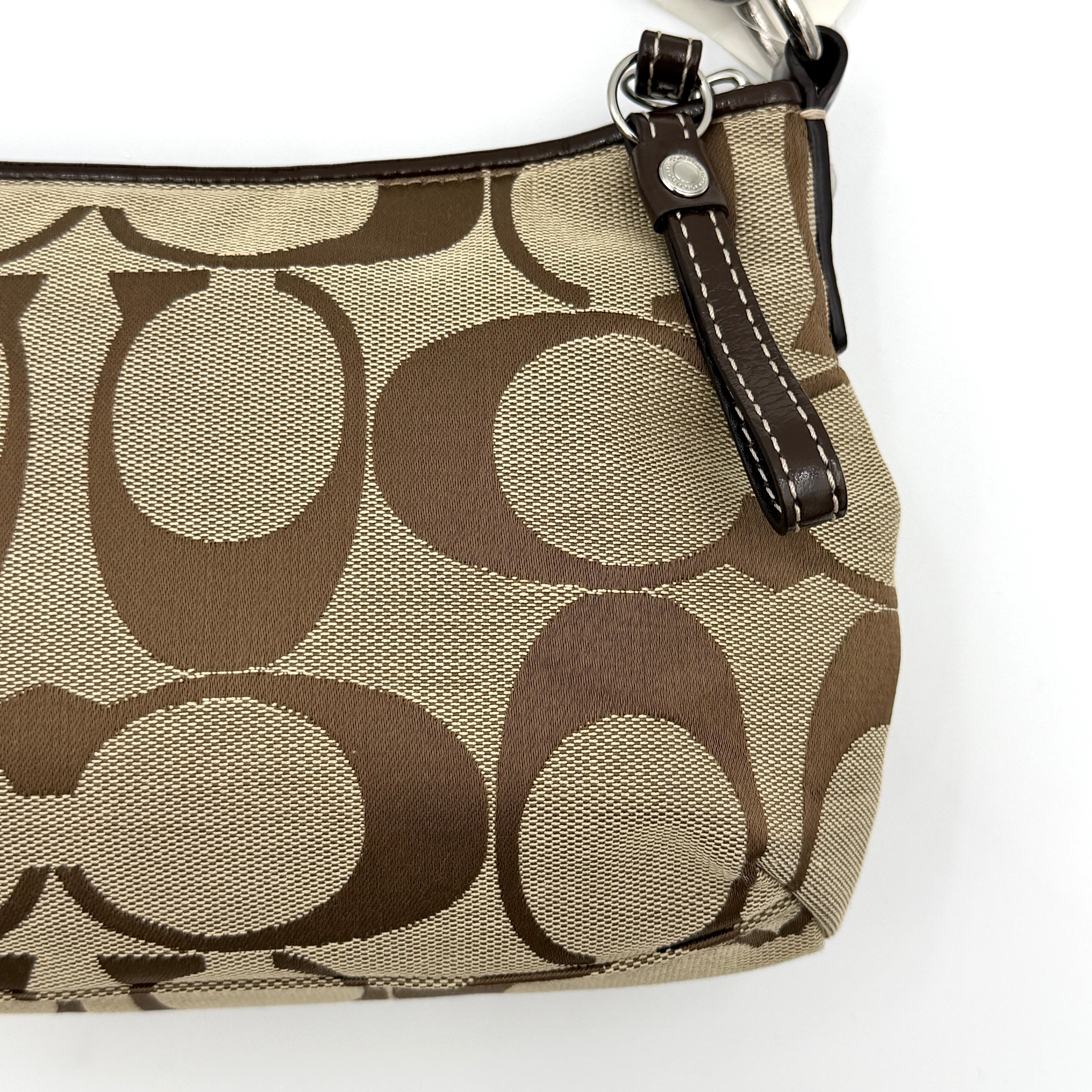 Coach khaki and mahogany signature jacquard shoulder bag with detachable strap and silver hardware displayed on a white background.
