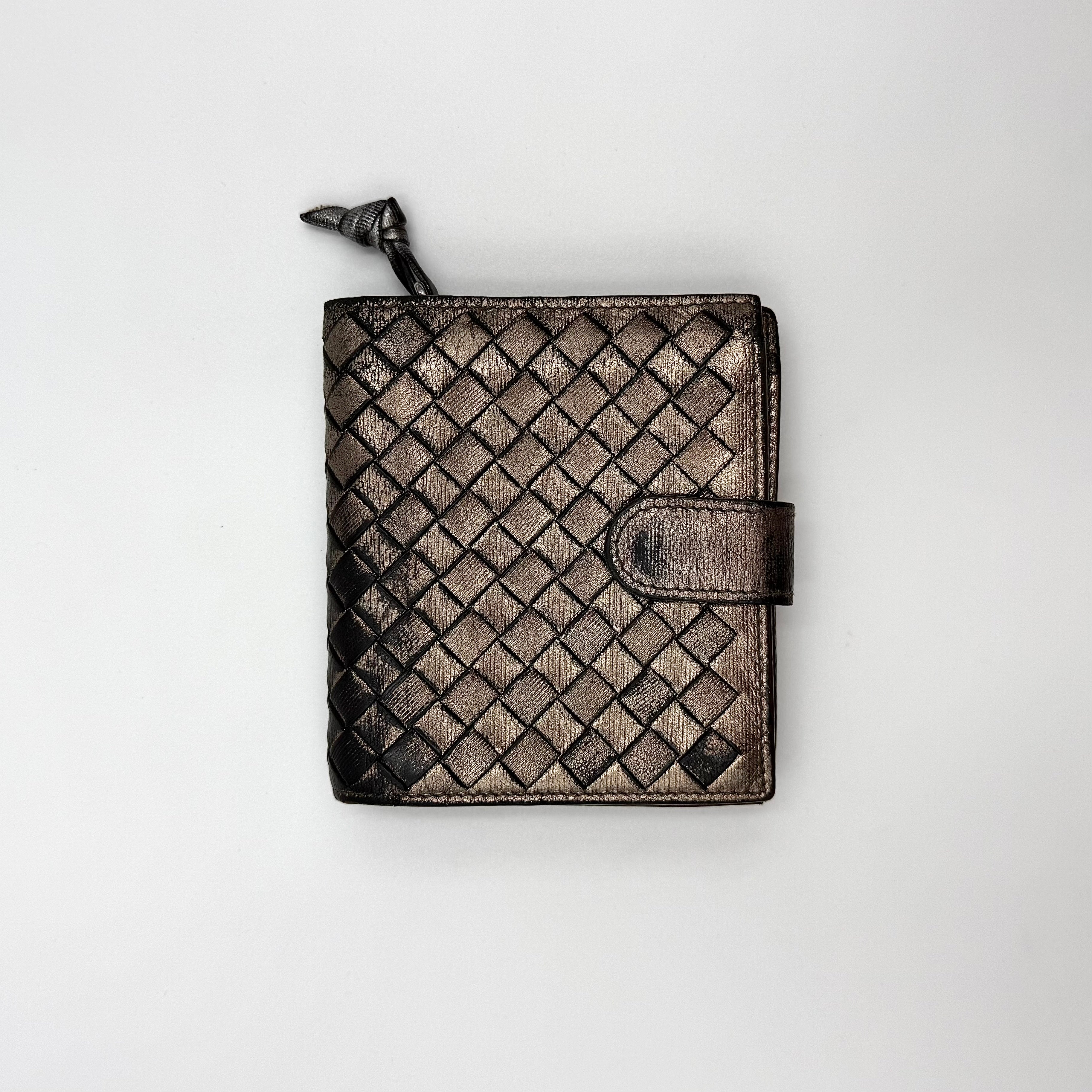 Bottega Veneta intrecciato metallic bronze leather wallet with snap tab and zip compartment.