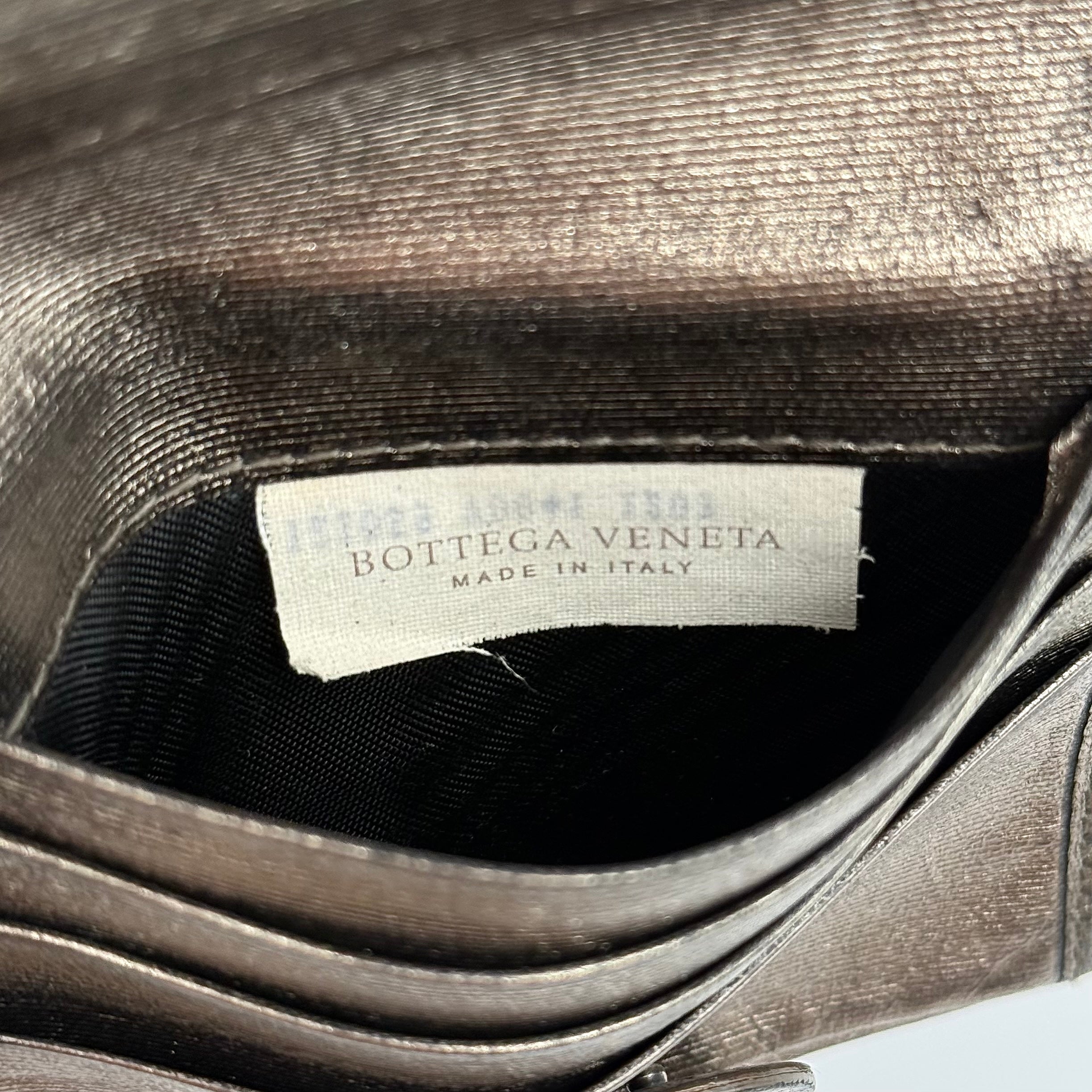 Bottega Veneta intrecciato metallic bronze leather wallet with snap tab and zip compartment.