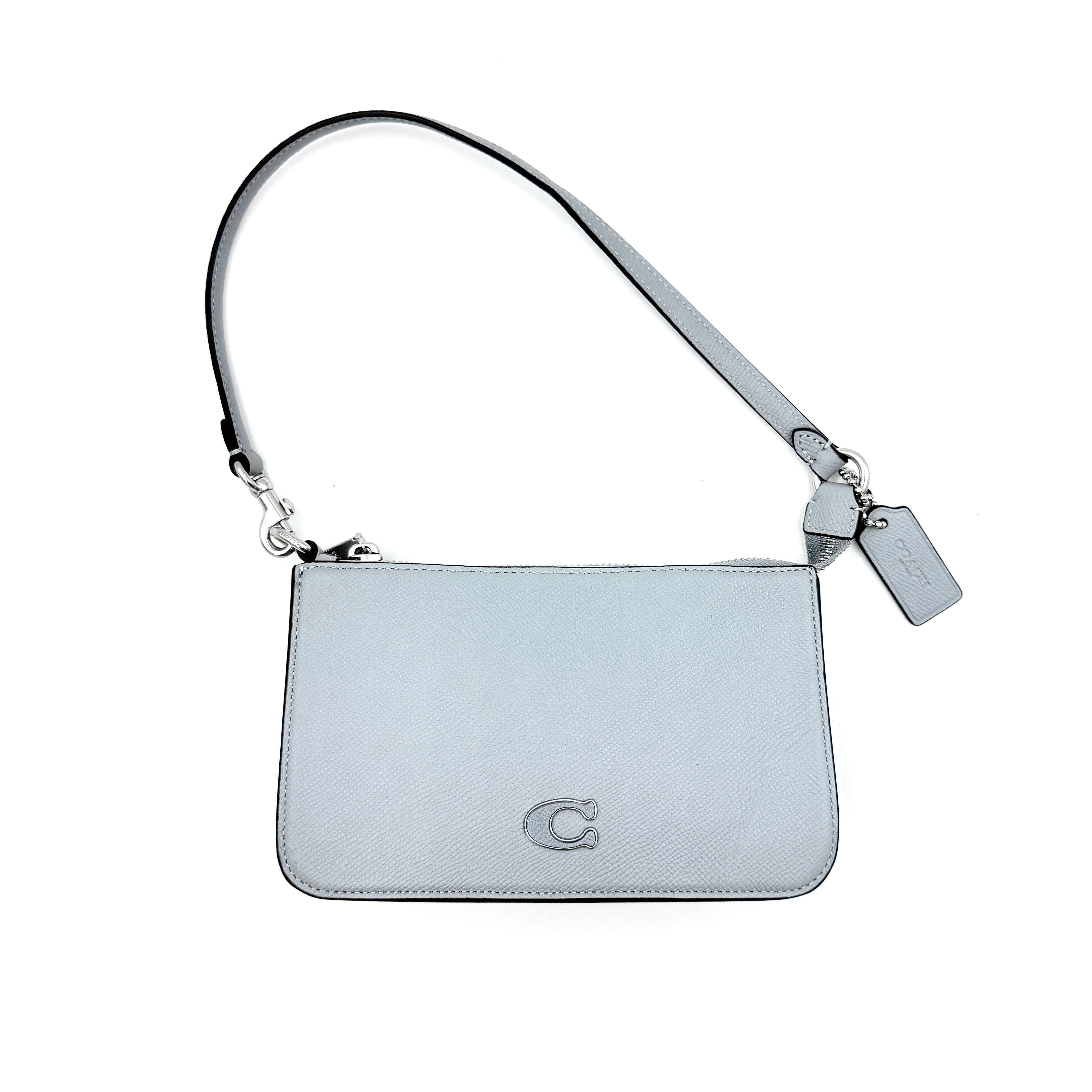 Sky blue Coach grained leather shoulder bag with silver-tone C plaque and short strap, displayed against a white background.